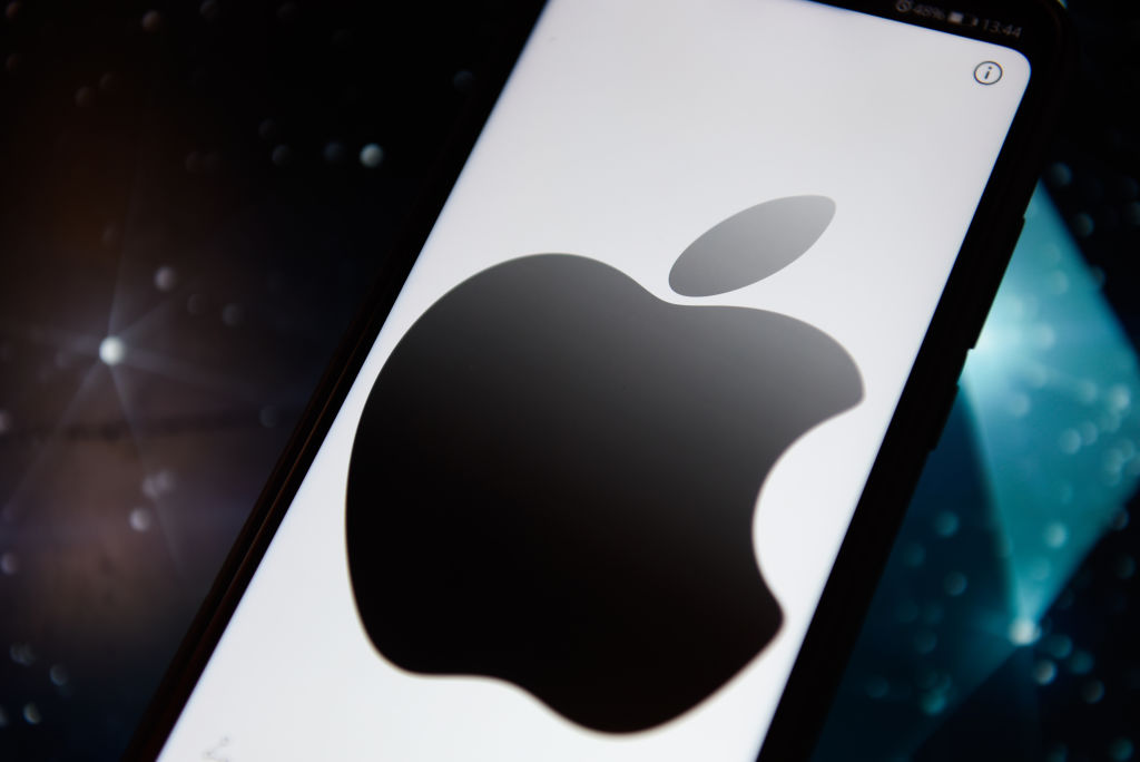In this photo illustration an Apple logo seen displayed on a