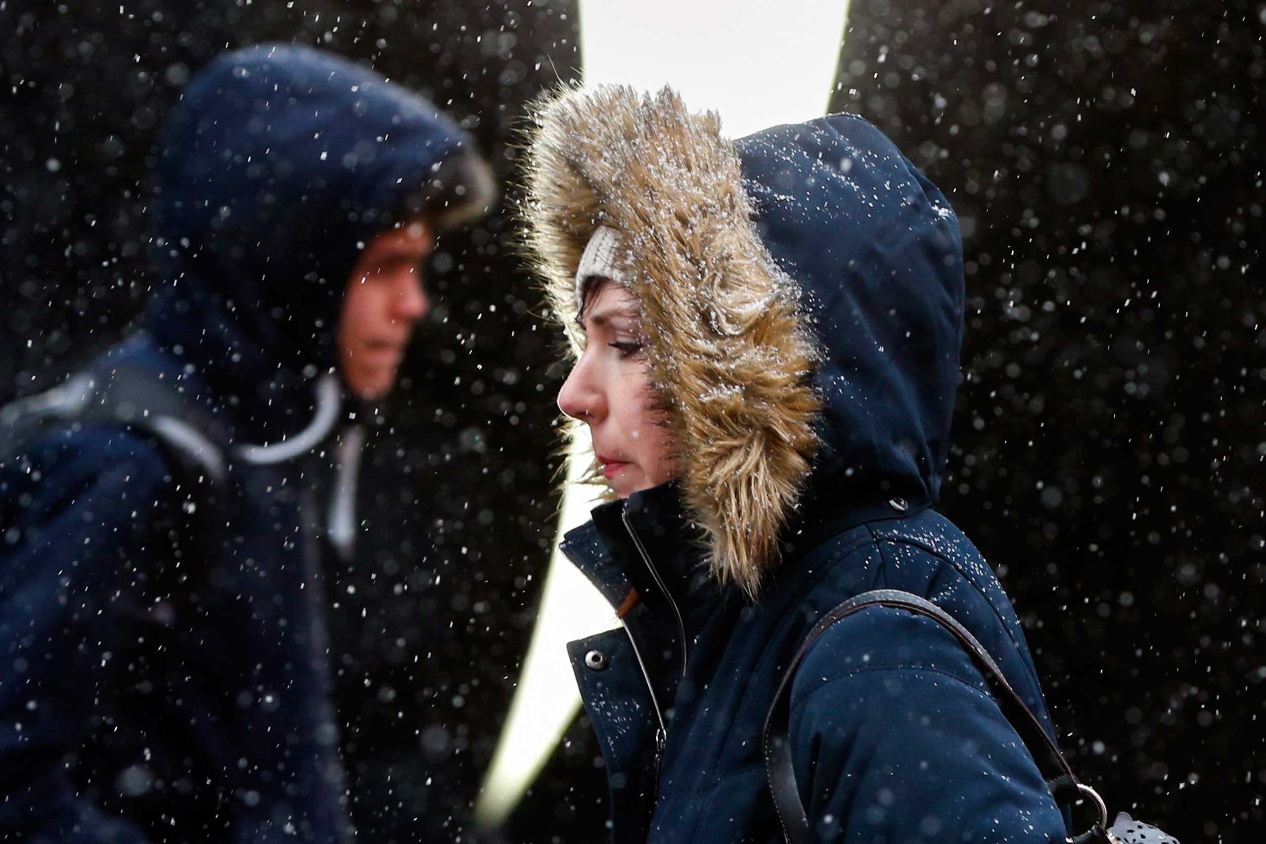 People walk through Times Square during snowfall in New York, March 3, 2015.