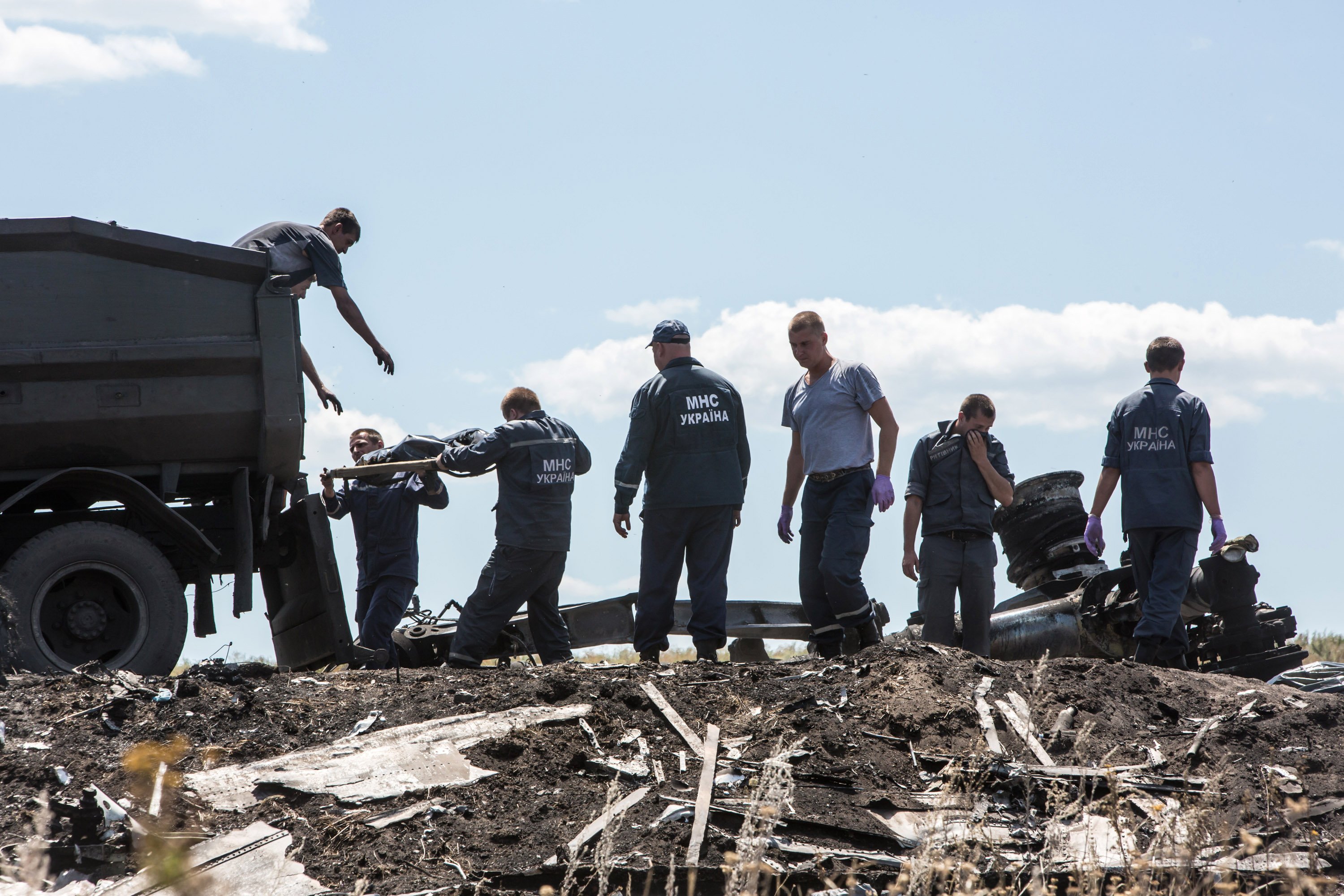 Personnel from the Ukrainian Emergencies Ministry load the bodies of victims of Malaysia Airlines flight MH17 into a truck at the crash site on July 21, 2014 in Grabovo, Ukraine.