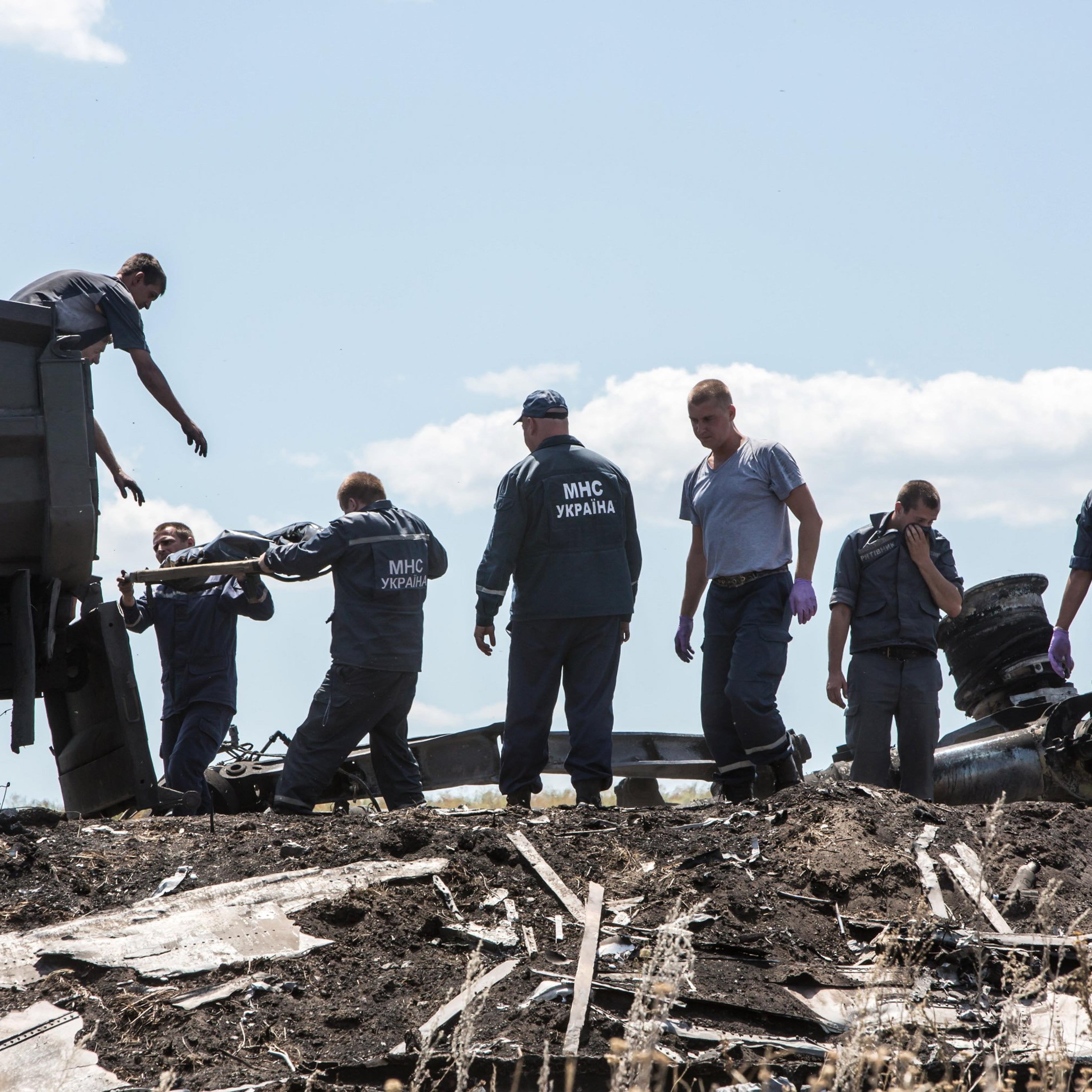Personnel from the Ukrainian Emergencies Ministry load the bodies of victims of Malaysia Airlines flight MH17 into a truck at the crash site on July 21, 2014 in Grabovo, Ukraine.