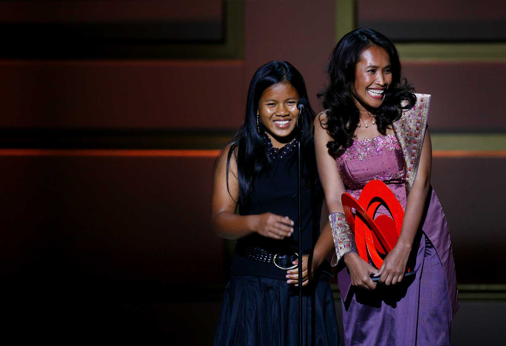 Cambodian activist Somaly Mam (R) accepts a "Woman of the Year" award with a child she rescued from sexual slavery, during the 2006 Glamour Magazine "Women of the Year" Honors award show in New York City October 30, 2006.
