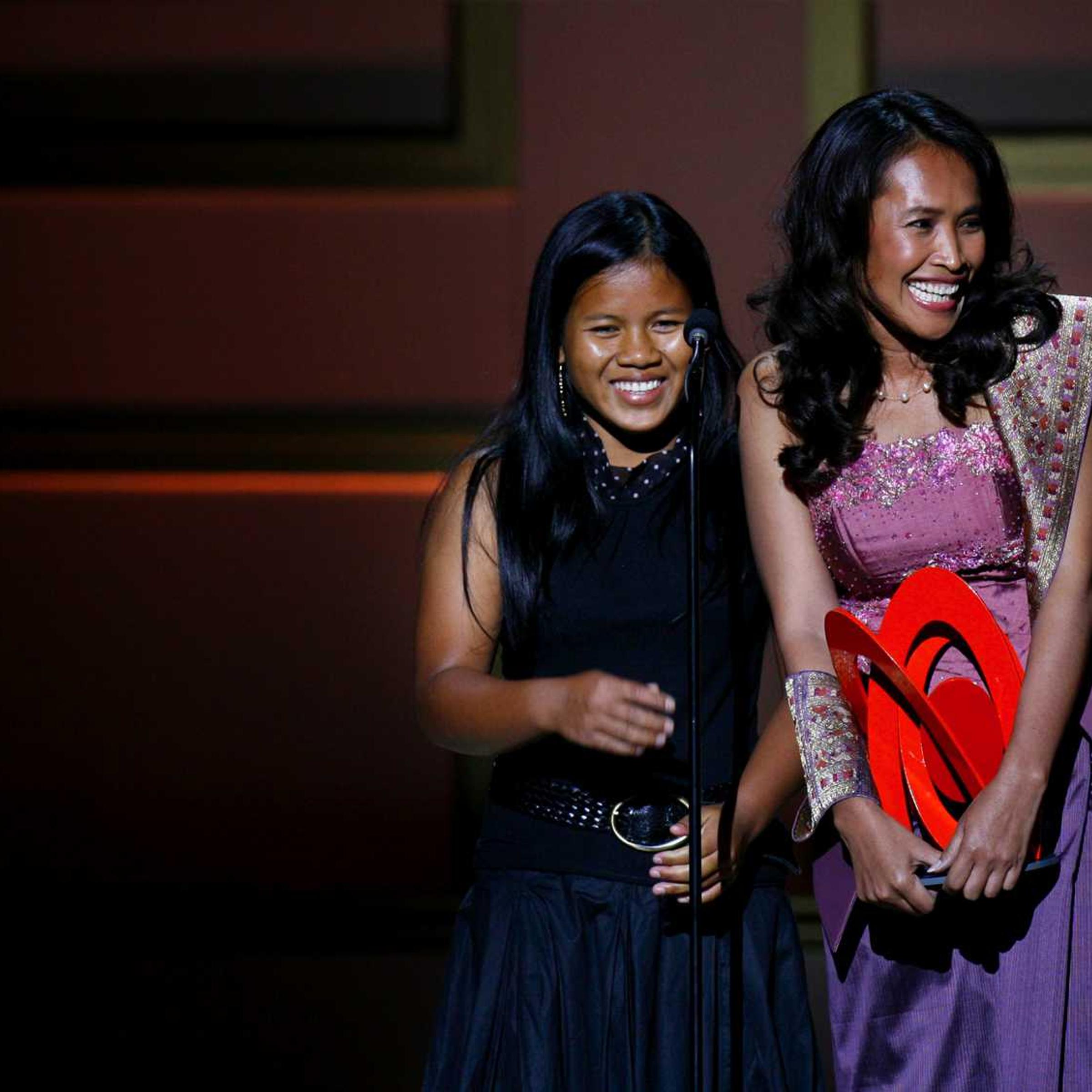 Cambodian activist Somaly Mam (R) accepts a "Woman of the Year" award with a child she rescued from sexual slavery, during the 2006 Glamour Magazine "Women of the Year" Honors award show in New York City October 30, 2006.