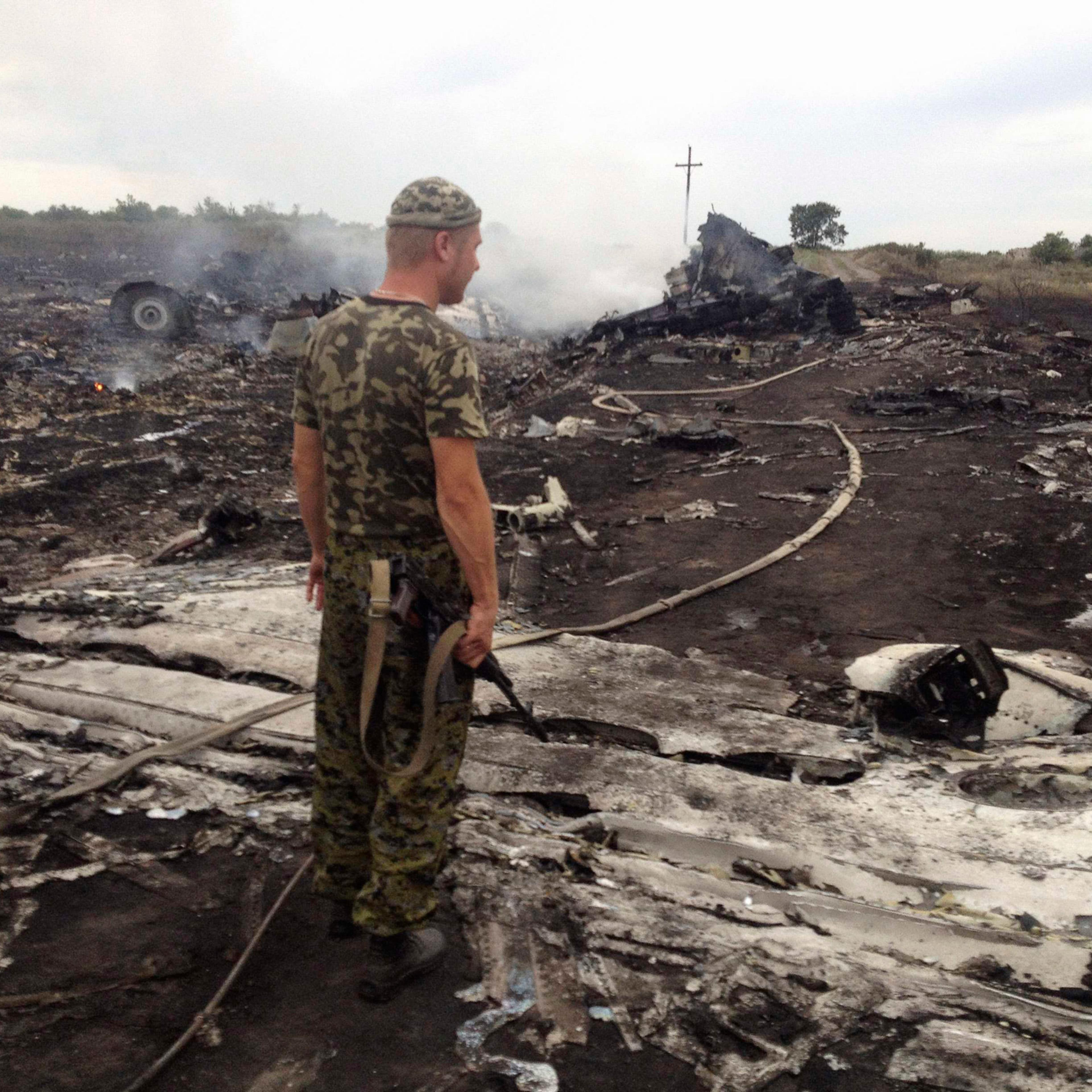 An armed pro-Russian separatist stands at a site of a Malaysia Airlines Boeing 777 plane crash in the settlement of Grabovo in the Donetsk region, July 17, 2014.