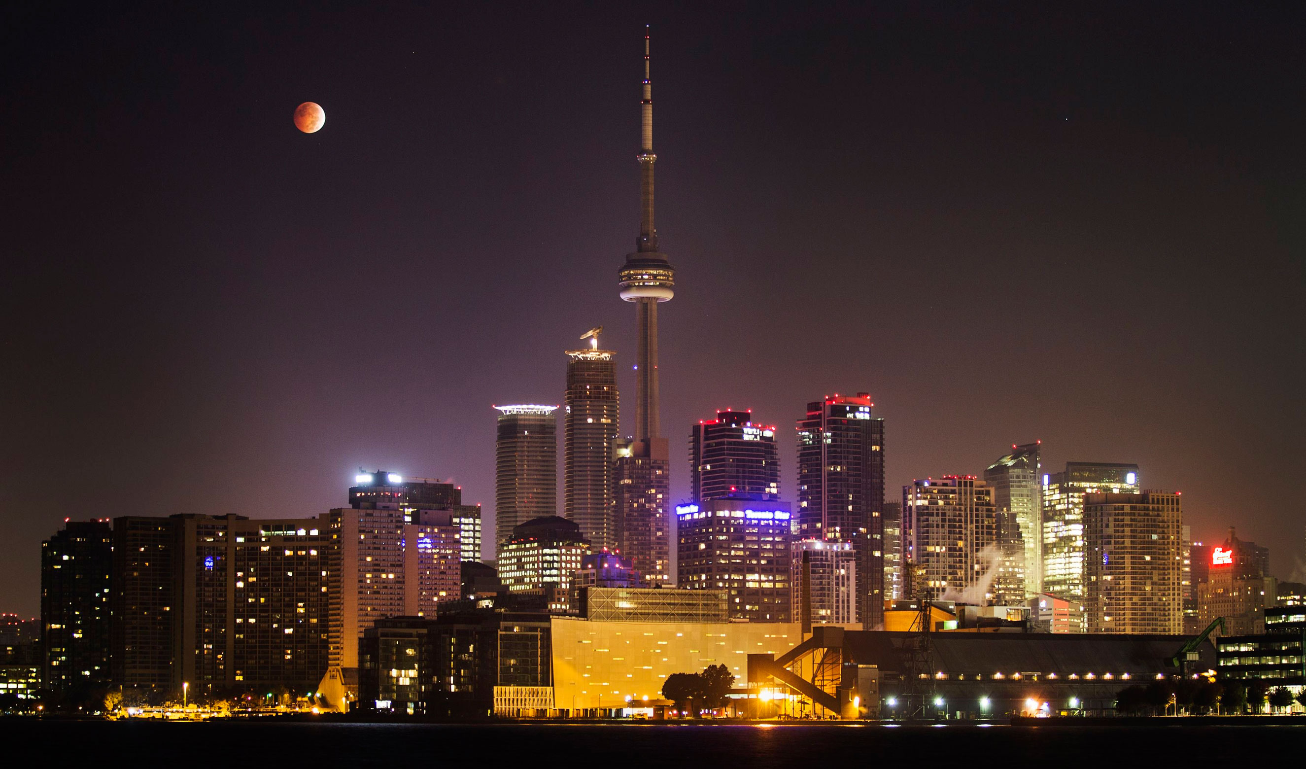 The moon during a total lunar eclipse behind the CN Tower and the skyline of Toronto on Oct. 8, 2014.