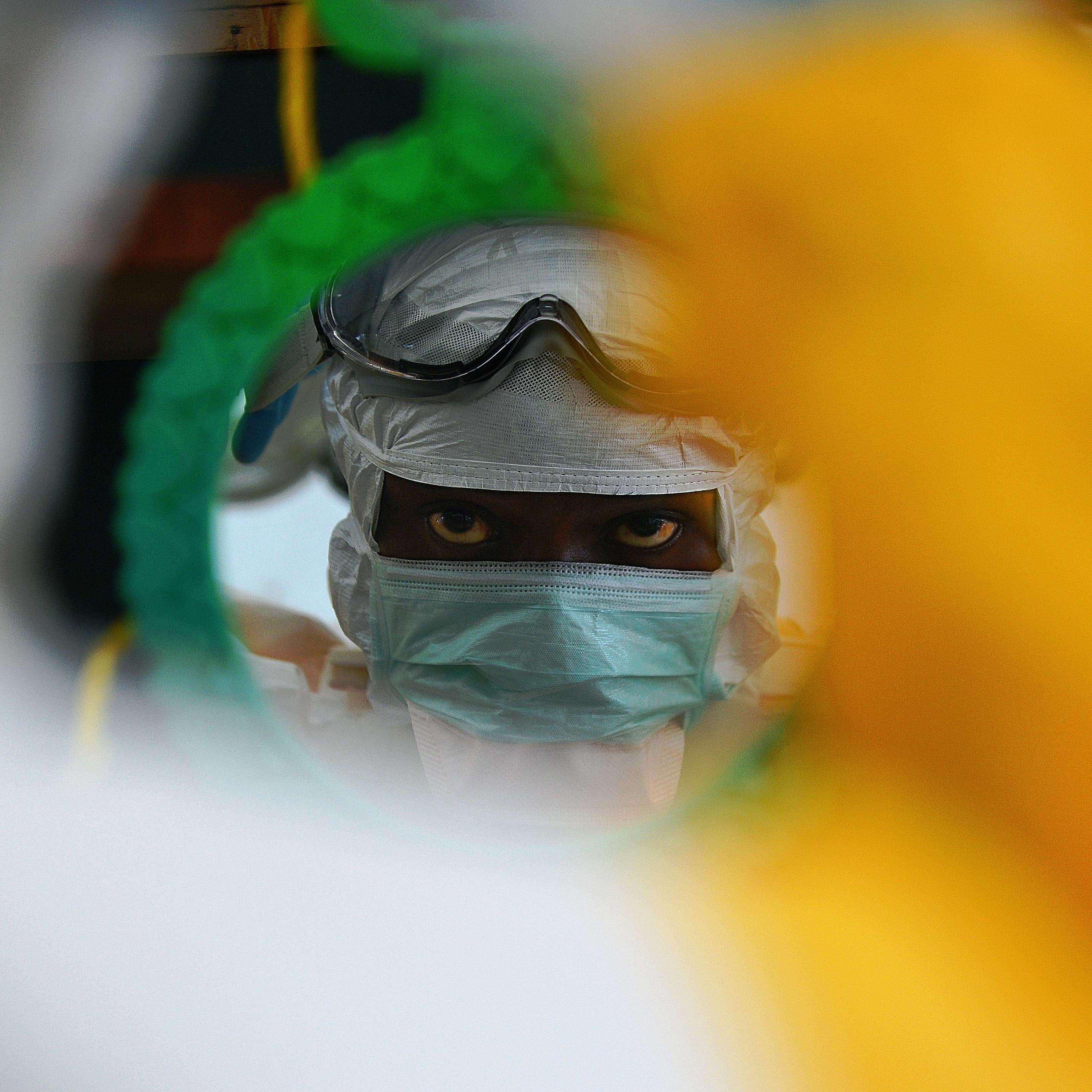 An MSF medical worker checks their protective clothing in a mirror at an MSF facility in Kailahun, Sierra Leone on August 15, 2014.