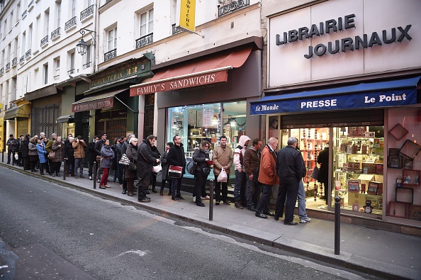 People wait outside a newsagents in Paris on Jan. 14, 2015 as the latest edition of French satirical newspaper Charlie Hebdo goes on sale.