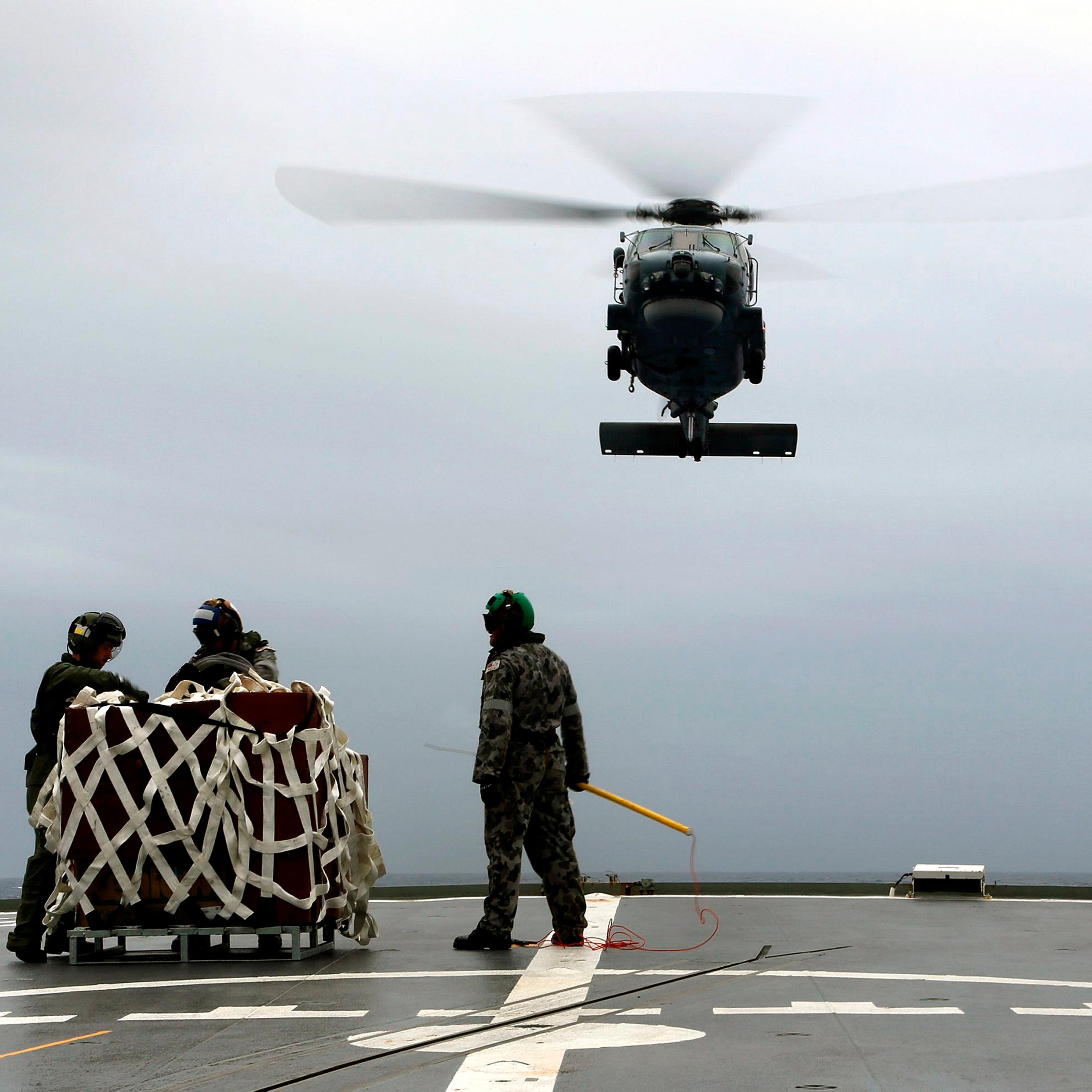A S-70B-2 Seahawk (Tiger 75) helicopter approaches the flight deck of Australian Navy ship HMAS Toowoomba to pick up supplies during a vertical replenishment at sea with HMAS Success as they continue to search for the missing Malaysian Airlines flight MH