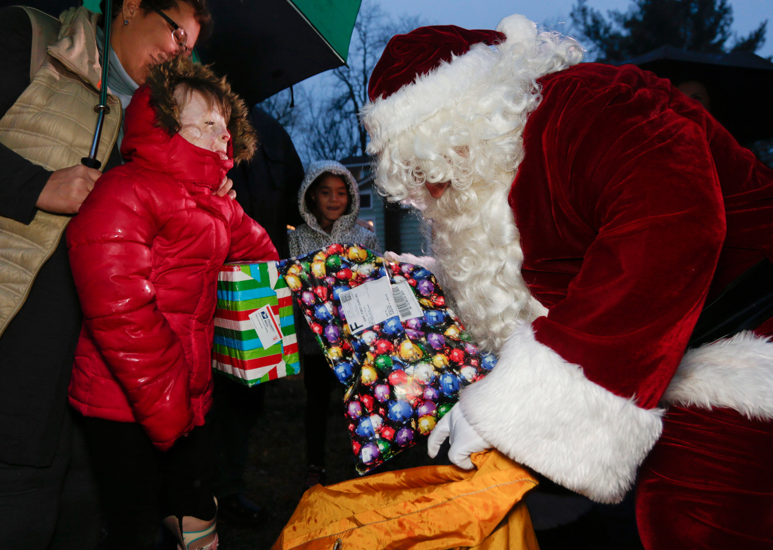 FILE - In this Dec. 17, 2015, file photo, Safyre Terry receives packages from Santa Claus in Rotterdam, N.Y. Terry, who lost her father and siblings in an arson fire that left her severely scarred is sharing the good cheer bestowed on her by the truckloa