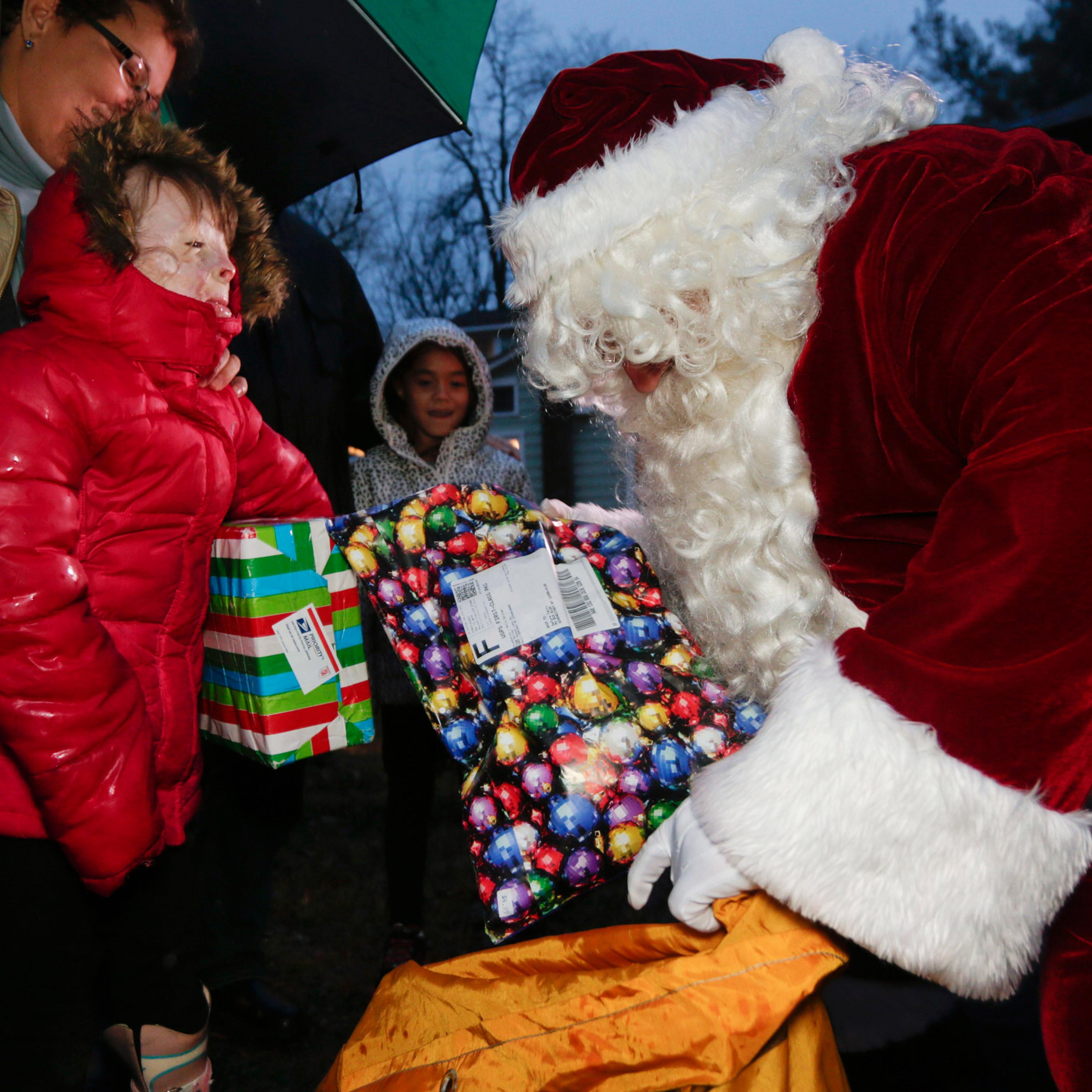 FILE - In this Dec. 17, 2015, file photo, Safyre Terry receives packages from Santa Claus in Rotterdam, N.Y. Terry, who lost her father and siblings in an arson fire that left her severely scarred is sharing the good cheer bestowed on her by the truckloa