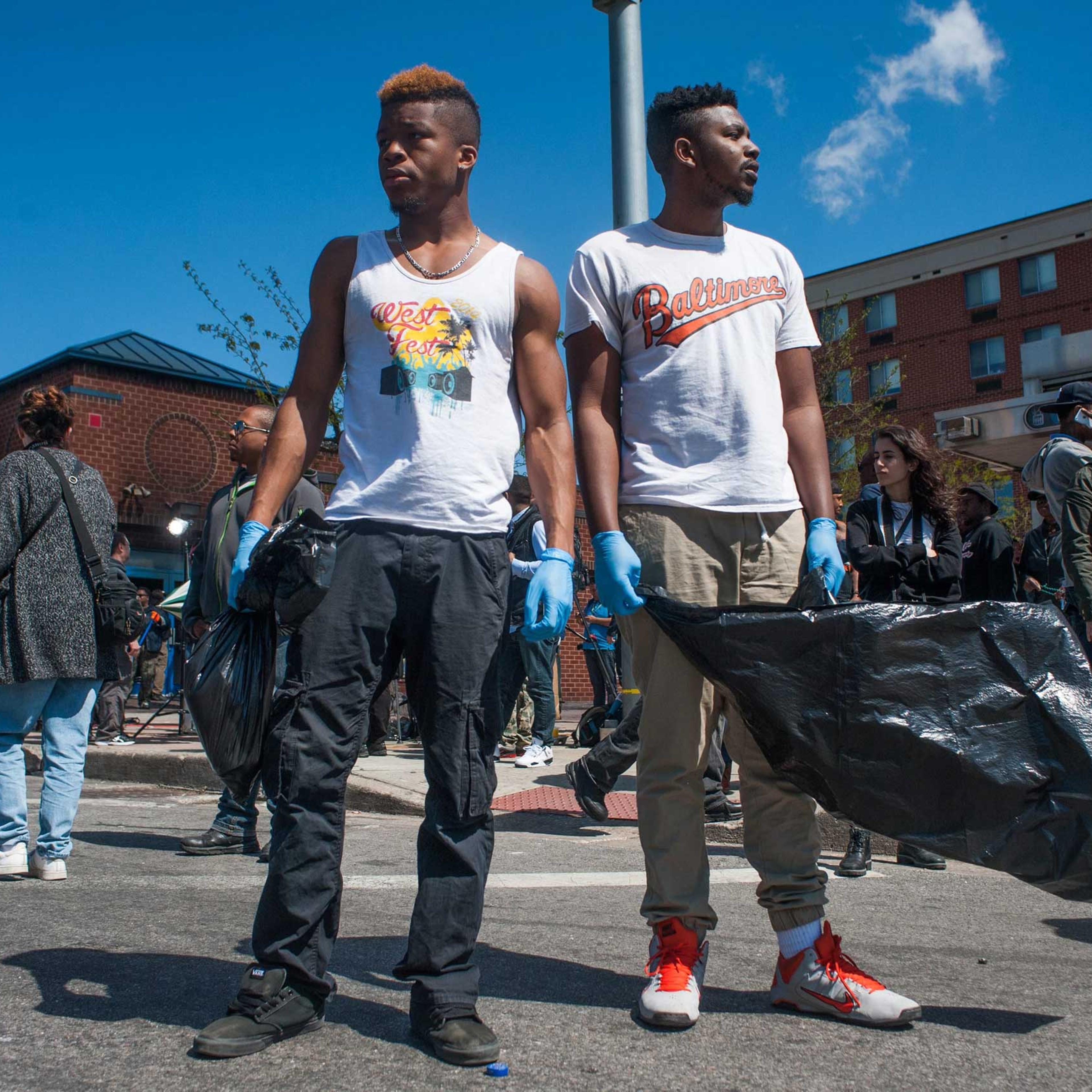 Cleanup volunteers stand in the intersection of North Avenue and Pennsylvania Avenue in the wake of riots in Baltimore on April 28, 2015.