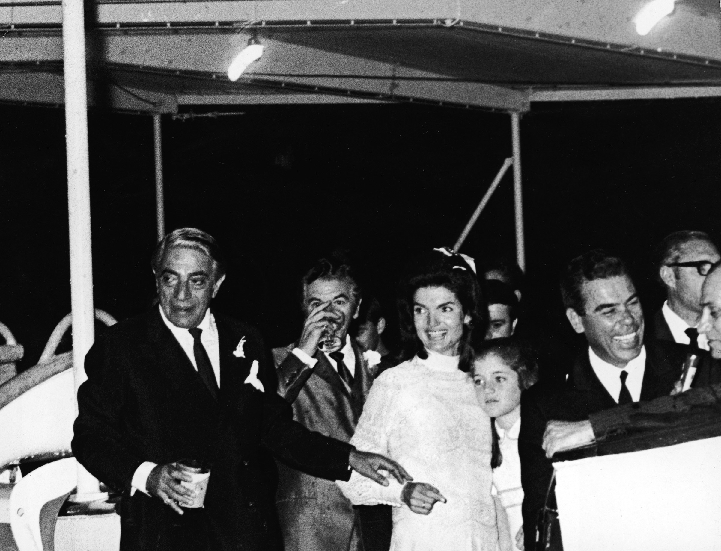 Jacqueline Kennedy Onassis, embracing her daughter, Caroline Kennedy, and her new husband, Greek shipping magnate Aristotle Onassis at their wedding reception aboard the yacht, <i>Christina</i>, shortly after they tied the knot on the Island of Skorpios, Greece, on Oct. 21, 1968.