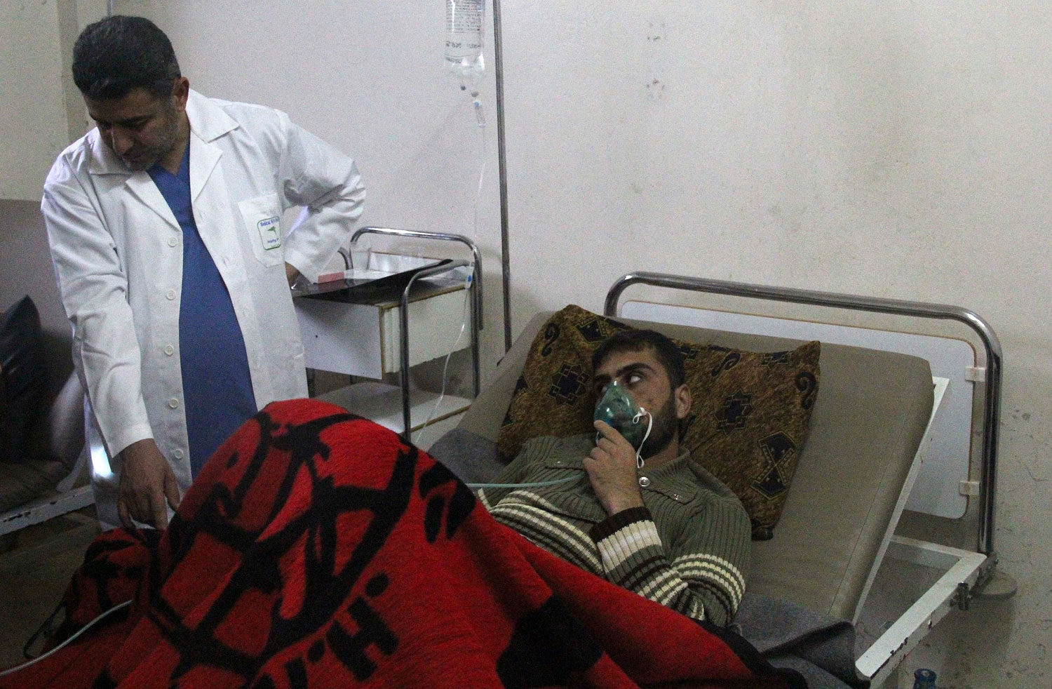 A man, affected by what activists say was a gas attack, breathes through an oxygen mask inside a field hospital in Kfar Zeita village in the central province of Hama, April 12, 2014.