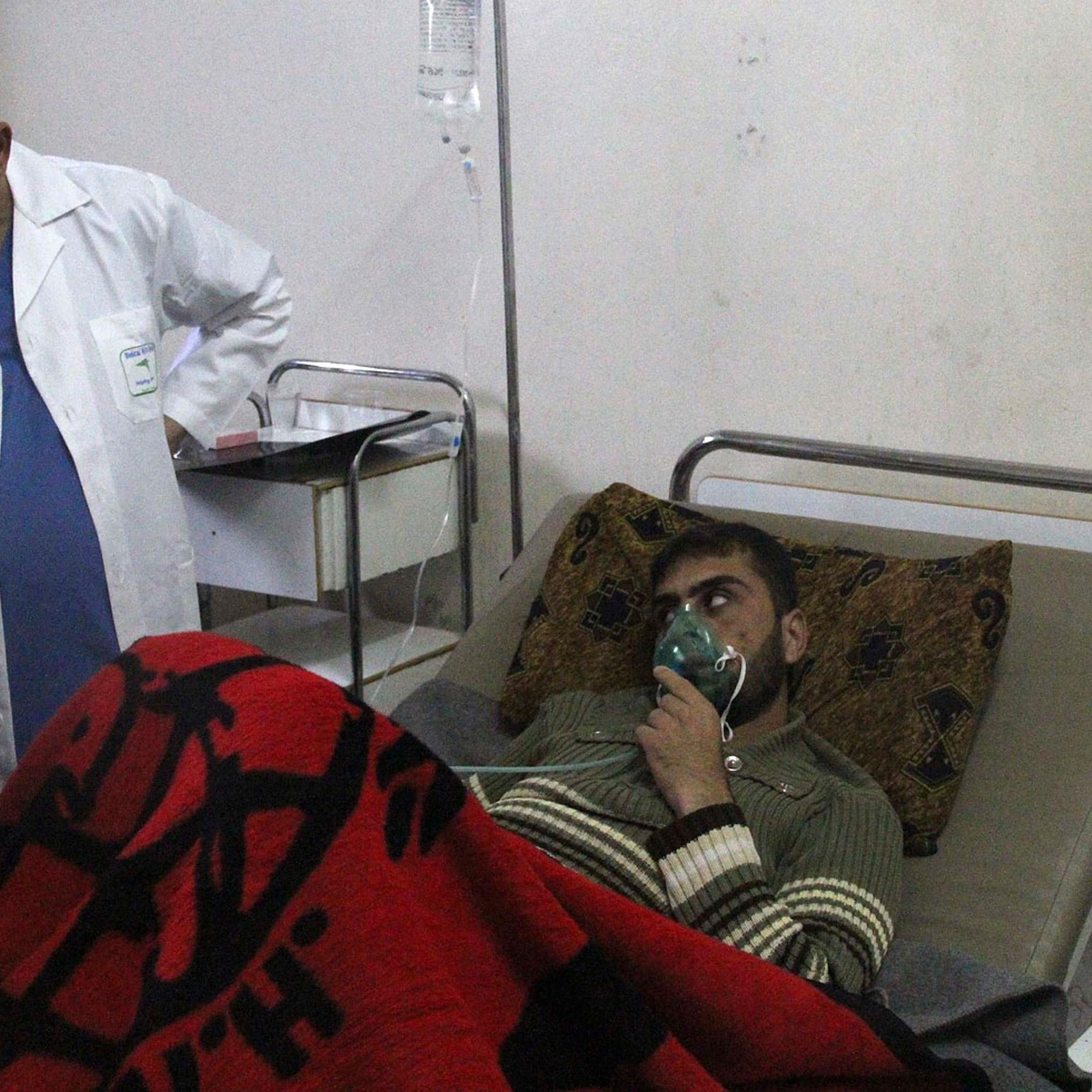 A man, affected by what activists say was a gas attack, breathes through an oxygen mask inside a field hospital in Kfar Zeita village in the central province of Hama, April 12, 2014.