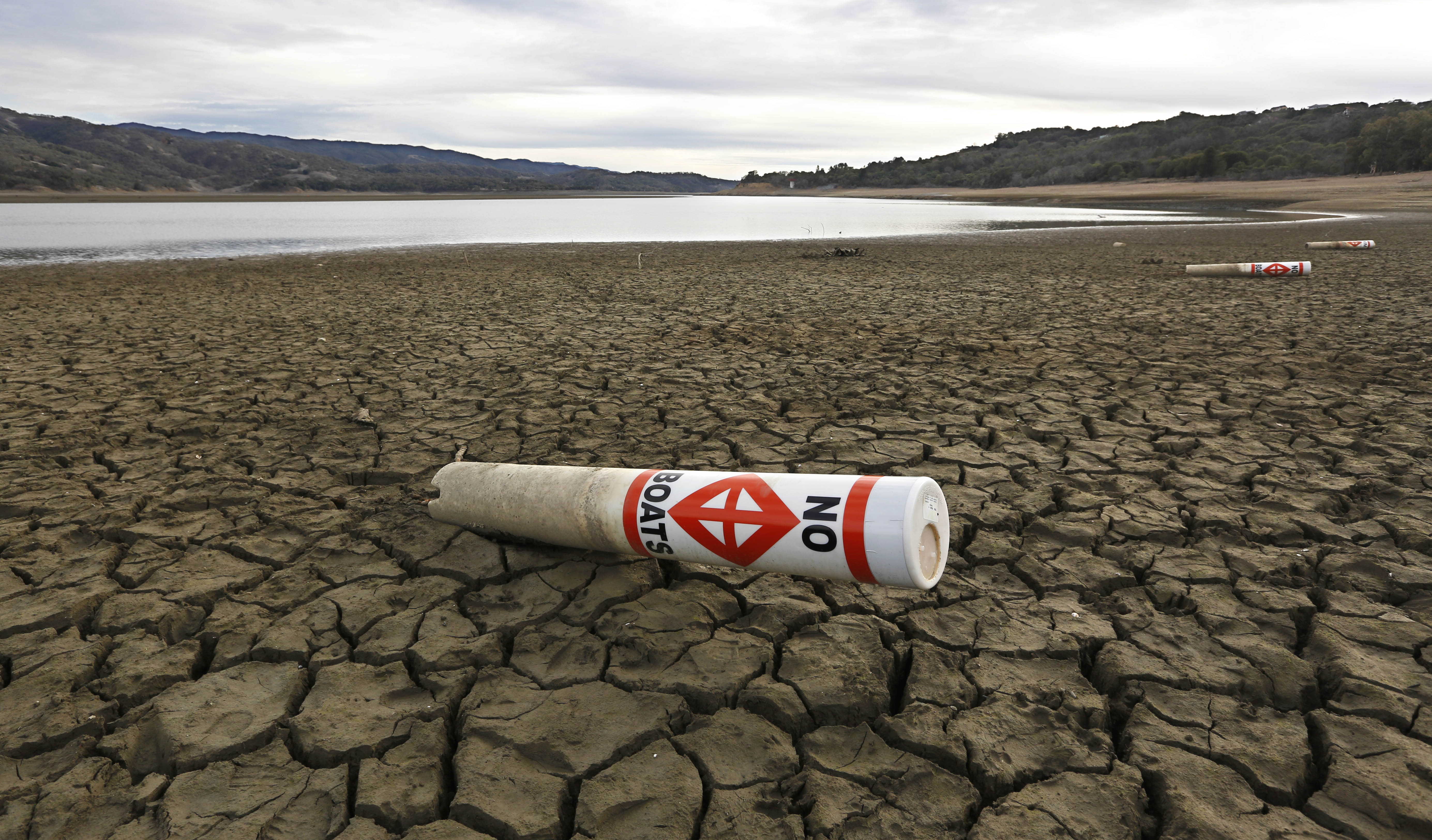In this Feb. 4, 2014 file photo, a warning buoy sits on the dry, cracked bed of Lake Mendocino near Ukiah, Calif.  