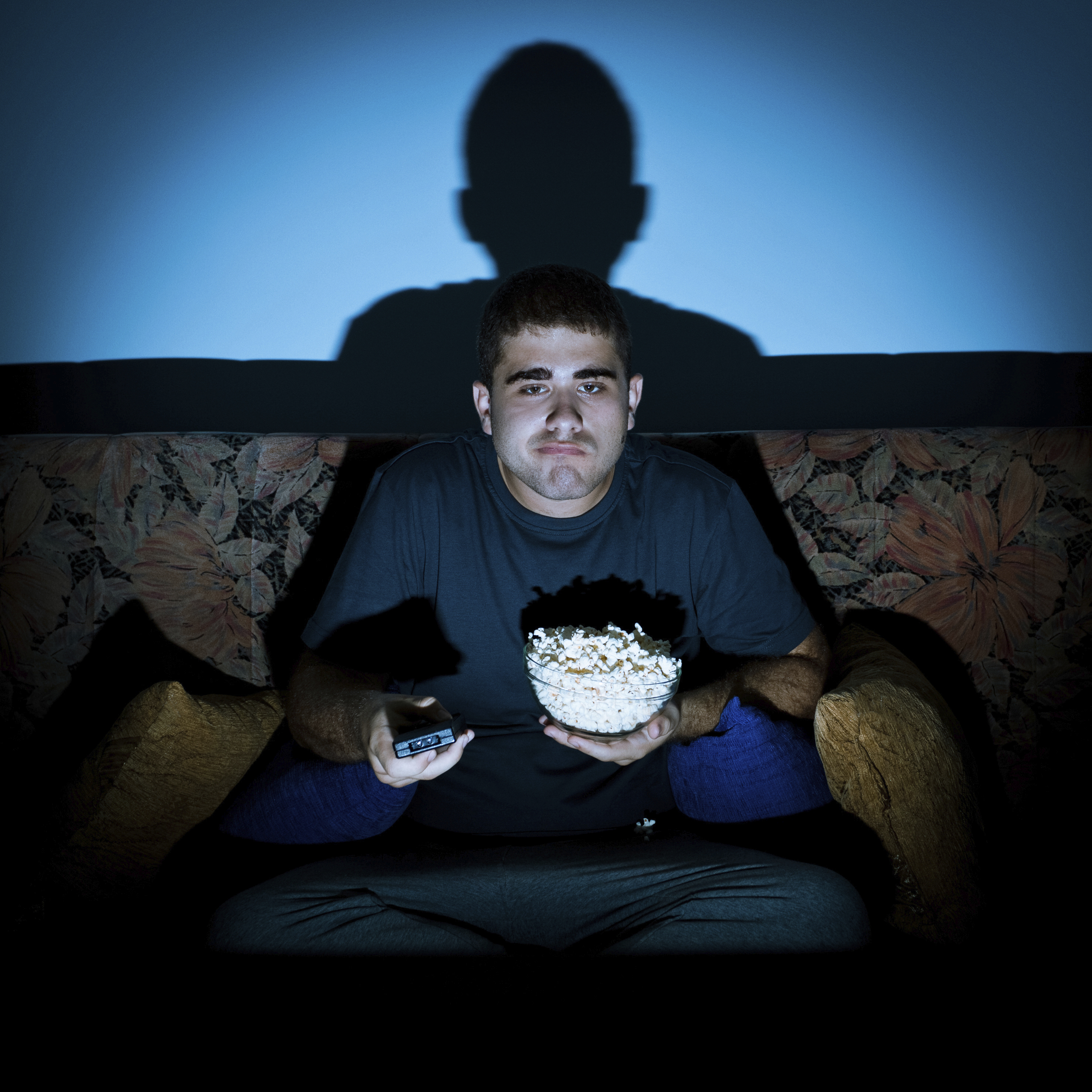 Man watching TV bored and eating