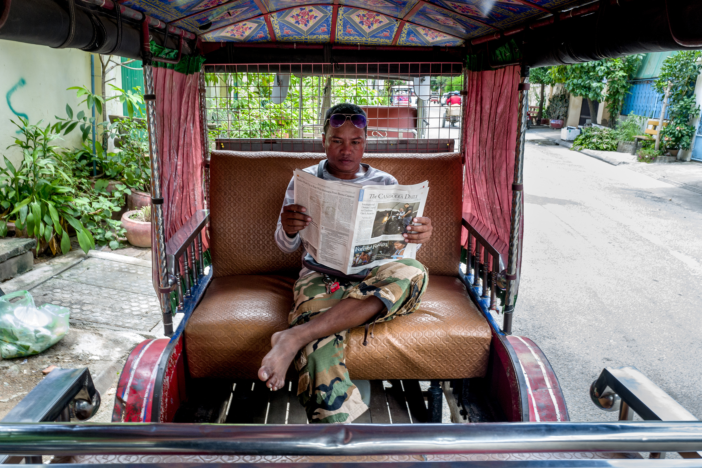 Yan Vivol, a tuk-tuk driver, reads The Cambodia Daily in Phnom Penh on Sept. 1, 2017.