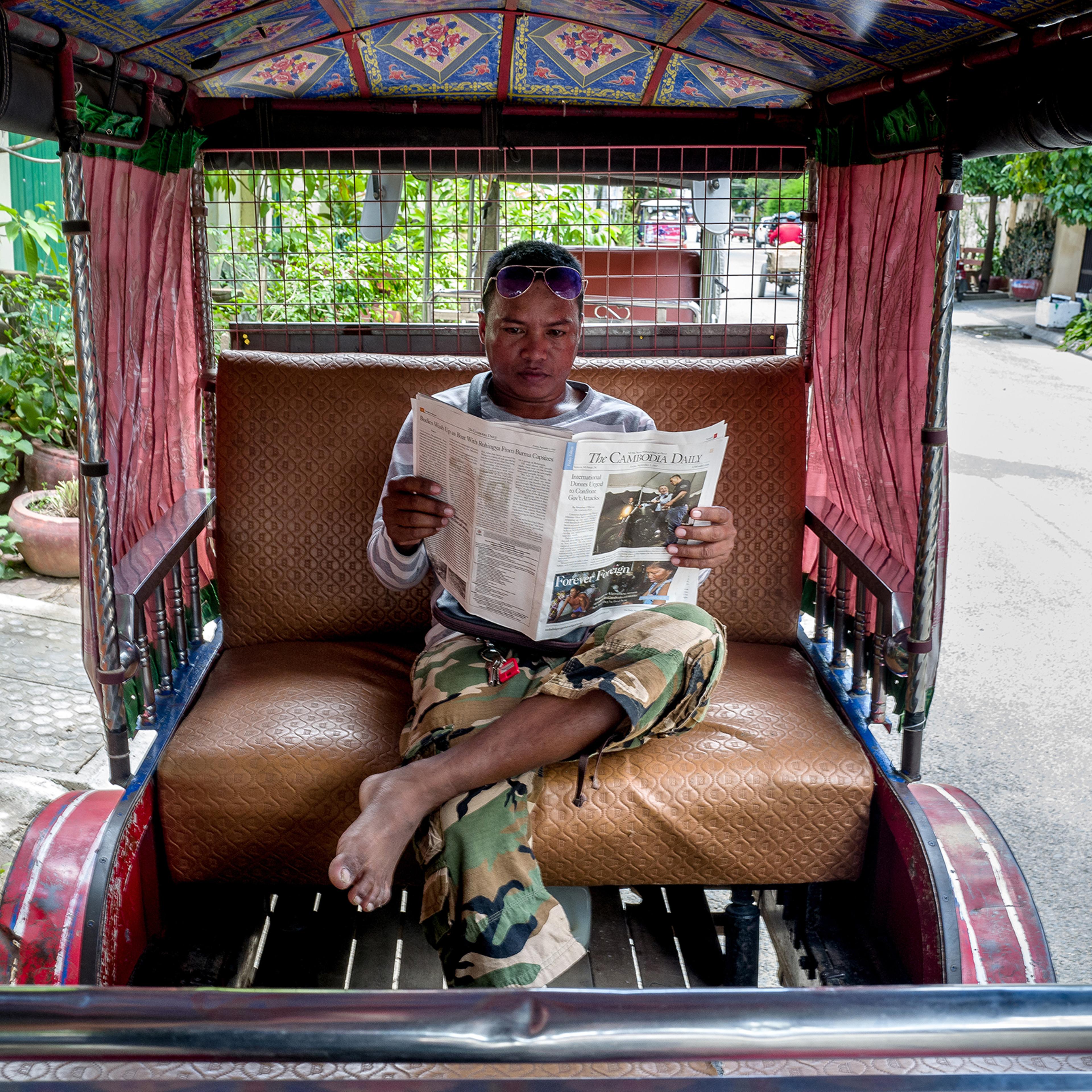 Yan Vivol, a tuk-tuk driver, reads The Cambodia Daily in Phnom Penh on Sept. 1, 2017.
