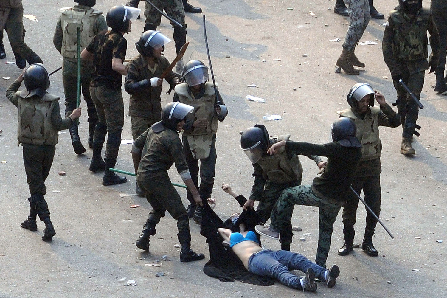 December 17, 2011. Egyptian army soldiers arrest a female protester during clashes at Tahrir Square in Cairo. Soldiers beat demonstrators with batons in Cairo's Tahrir Square on Saturday in a second day of clashes that have killed nine people and wounded more than 300, marring the first free election most Egyptians can remember.