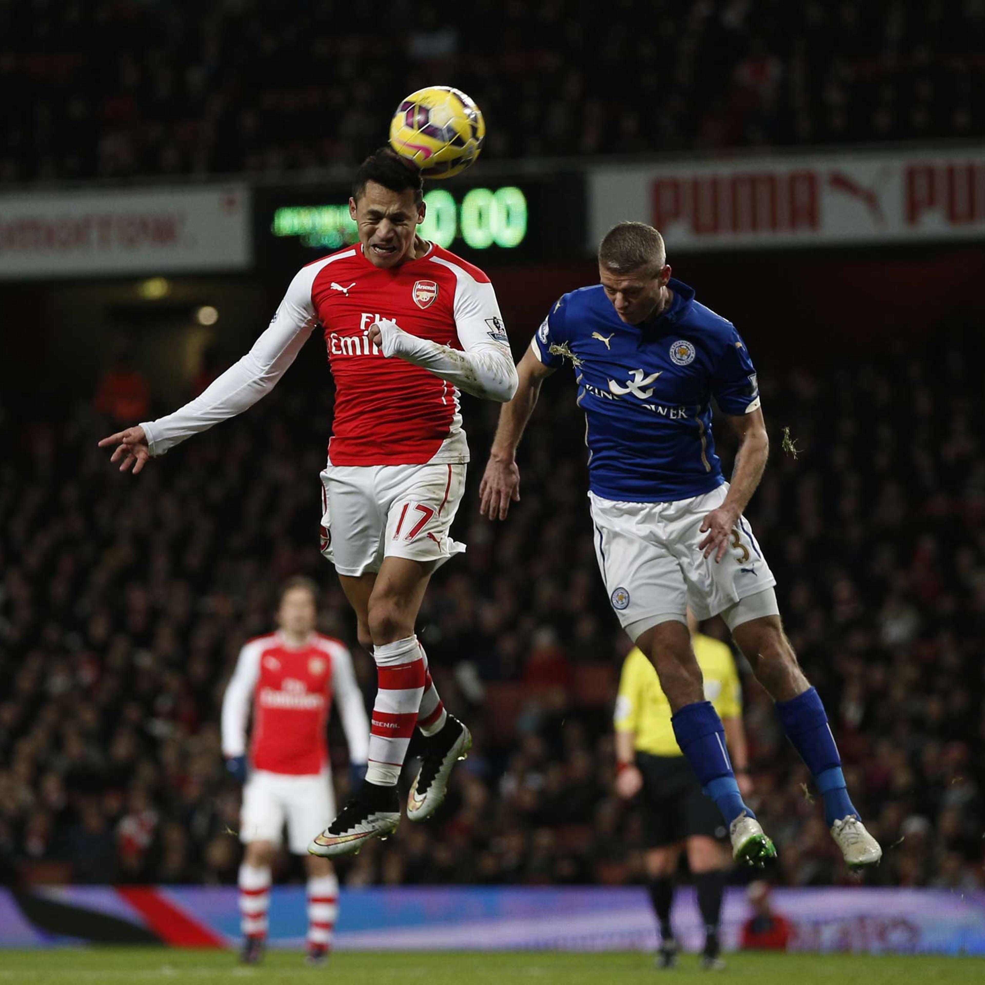 Arsenal's Chilean striker Alexis Sanchez heads the ball ahead of Leicester City's English defender Paul Konchesky during the English Premier League football match between Arsenal and and Leicester City at the Emirates Stadium in London on Feb. 10, 2015.