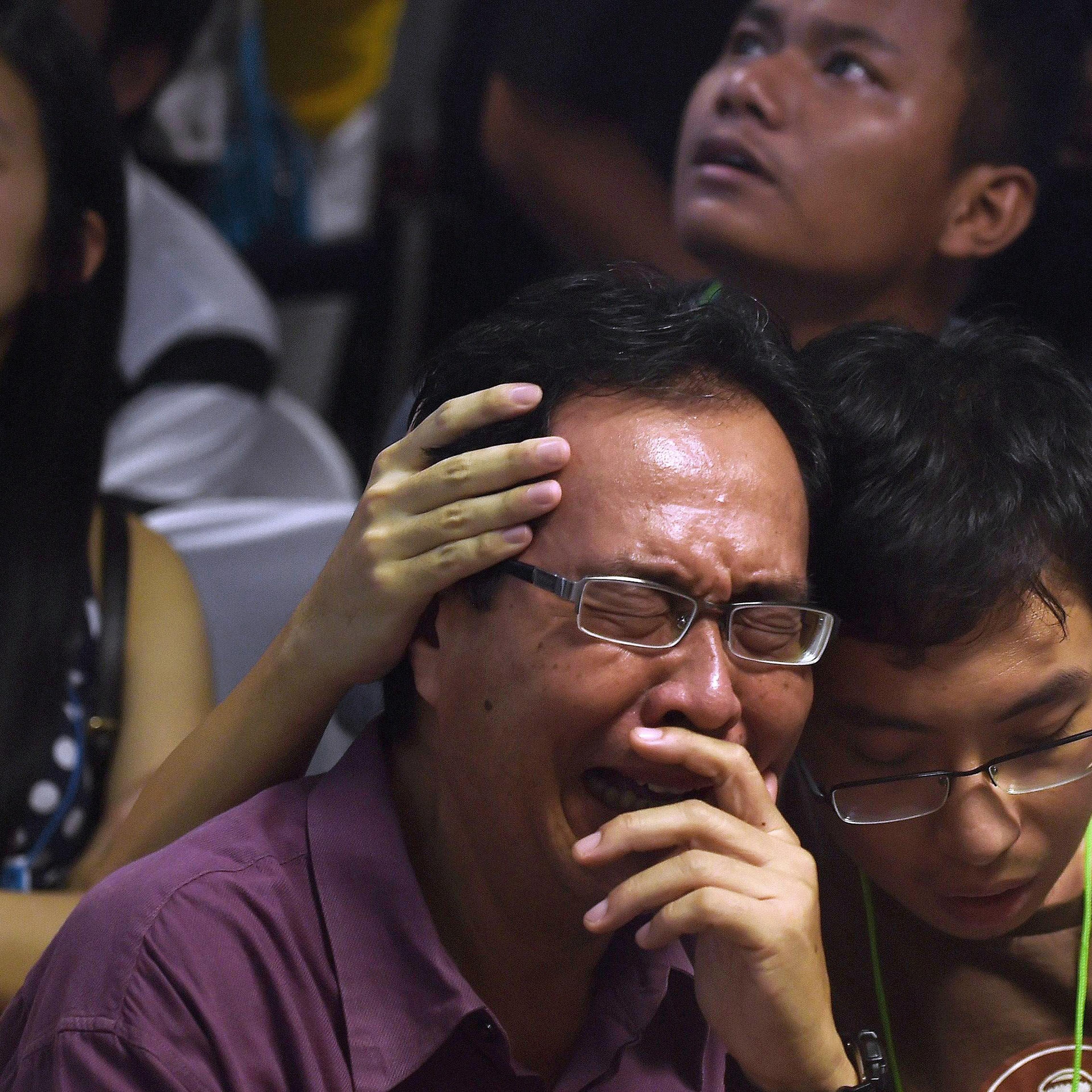 Family members of passengers onboard the missing AirAsia flight QZ8501 react after watching news reports showing an unidentified body floating in the Java sea, inside the crisis-centre set up at Juanda International Airport in Surabaya, Indonesia on Dec.
