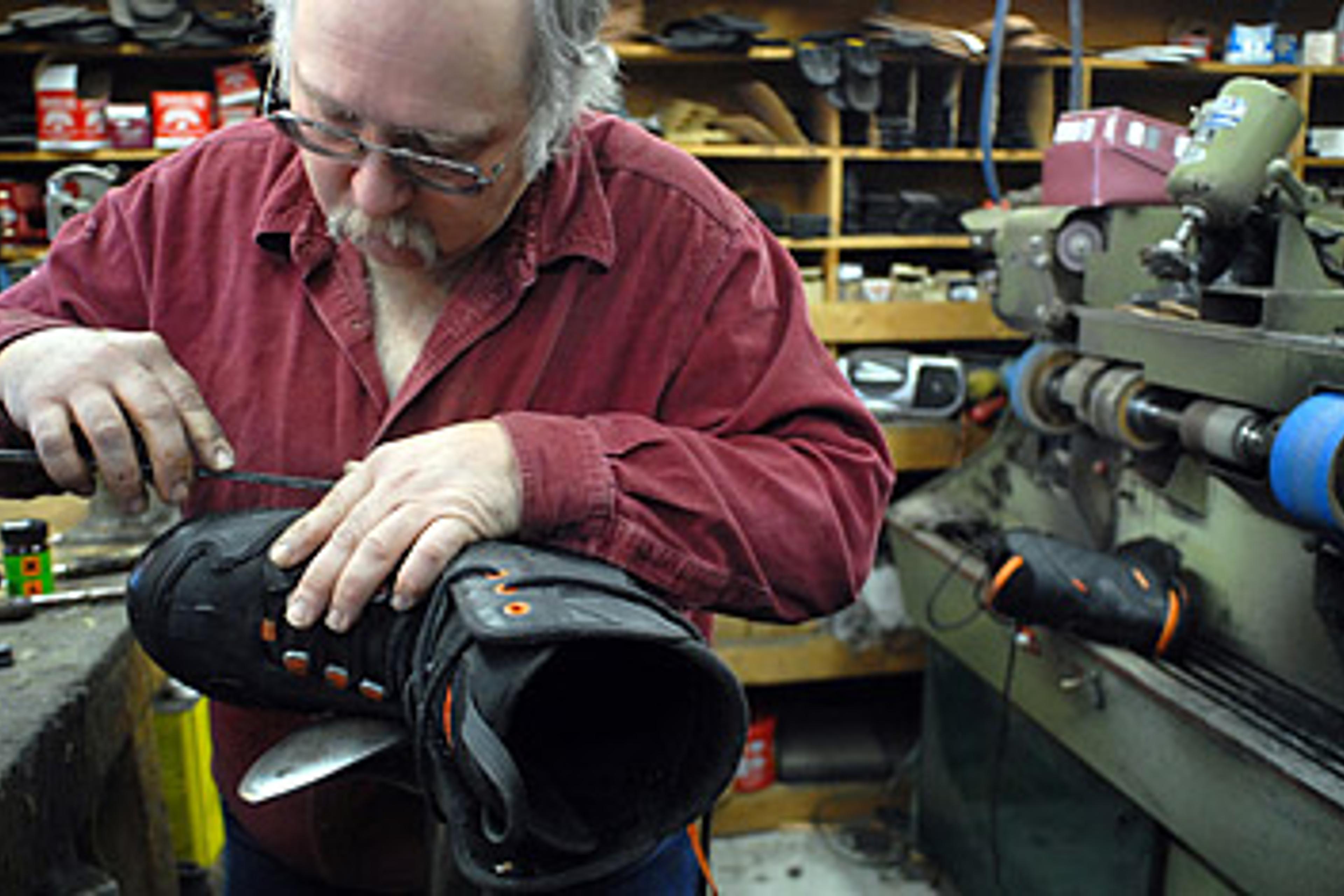 Joe Lynch, owner of Glenn's Shoe Repair, replaces a band of rubber on a snowcat boot at his shop in Kalispell, Mont.
