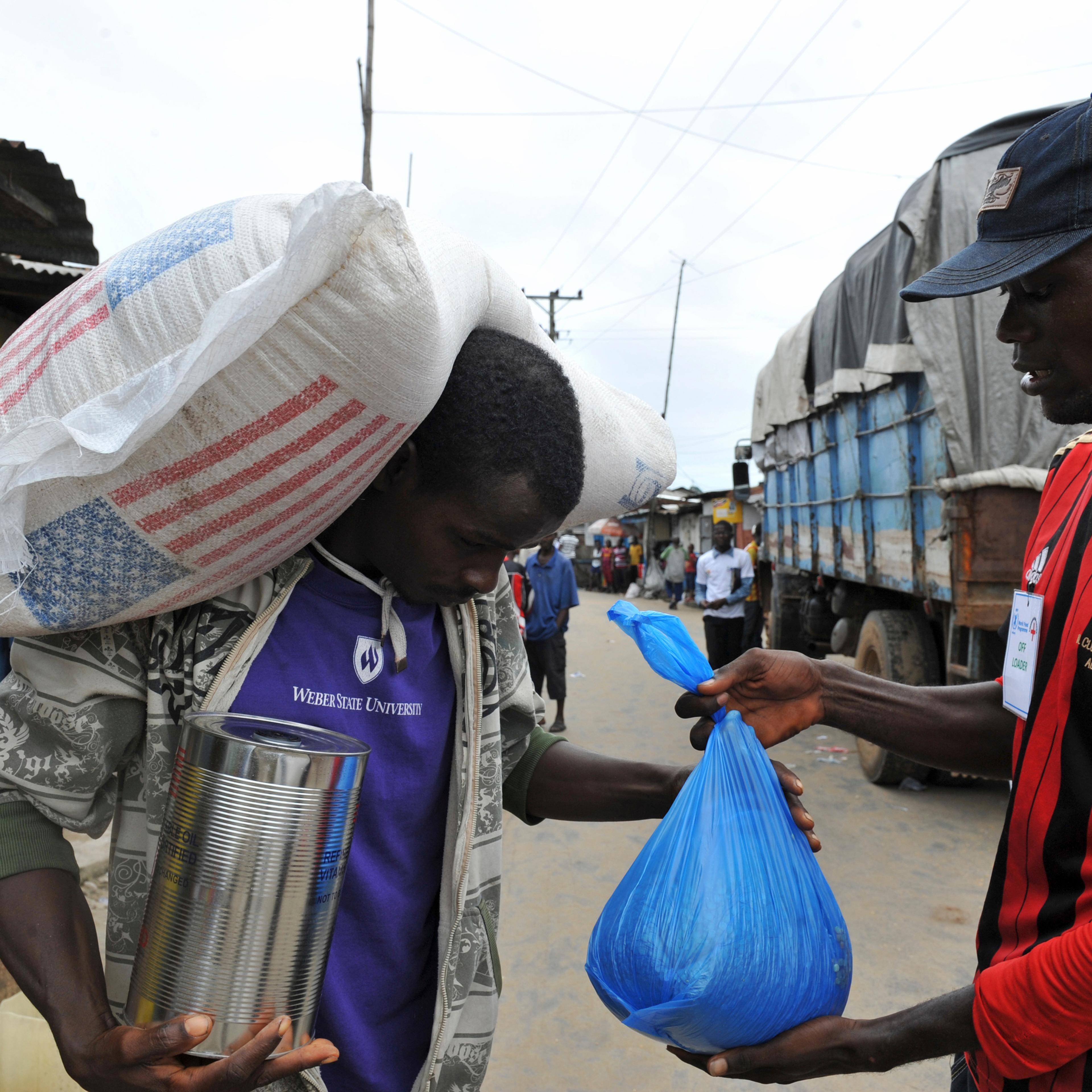 Resident of the West Point neighbourhood, which has been quarantined following an outbreak of Ebola, receives food rations from the United Nations World Food Programme (WFP) in Monrovia