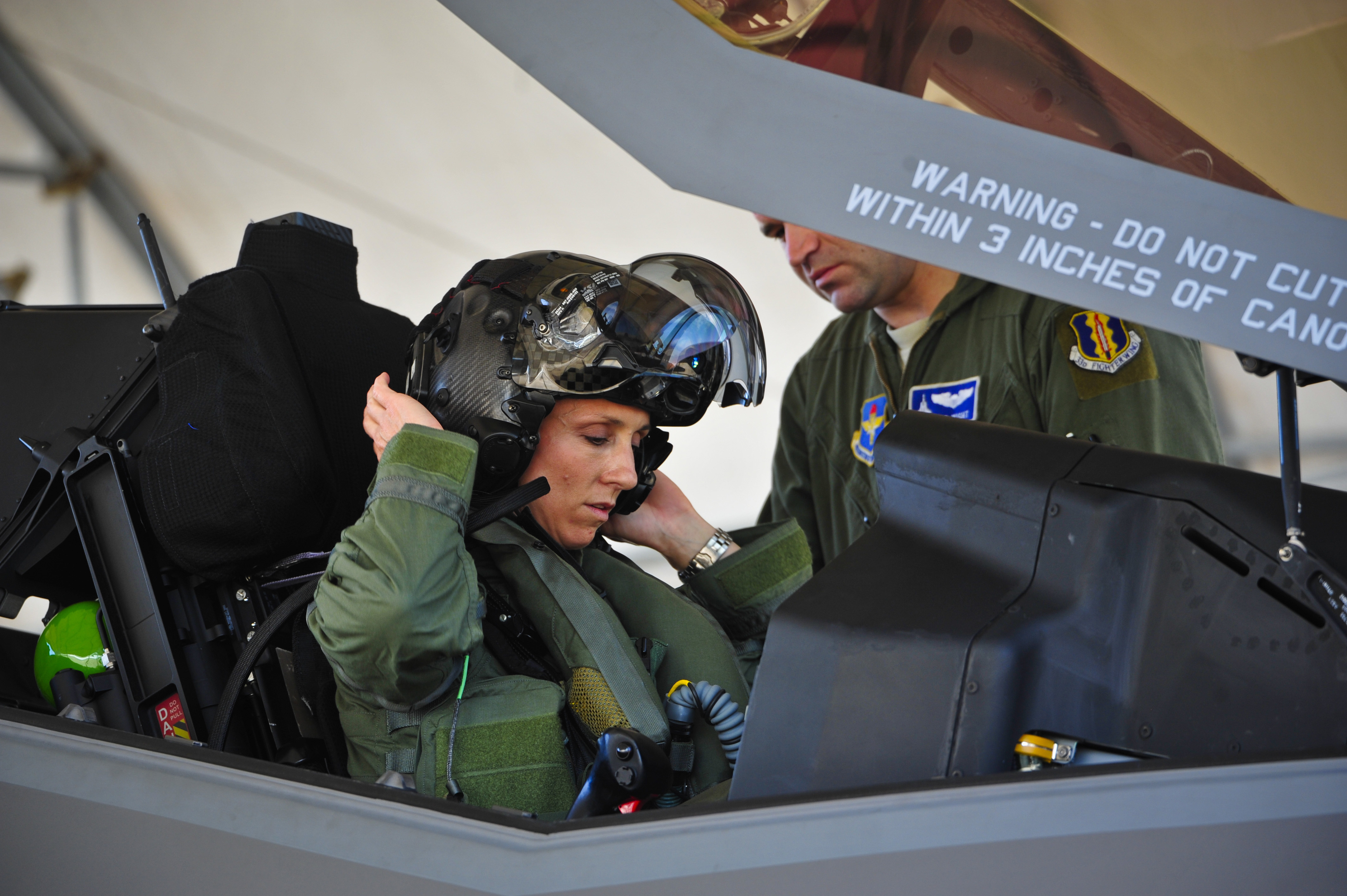 Lt. Col. Christine Mau, 33rd Operations Group deputy commander, puts on her helmet before taking her first flight in the F-35A on Eglin Air Force Base, Fla.