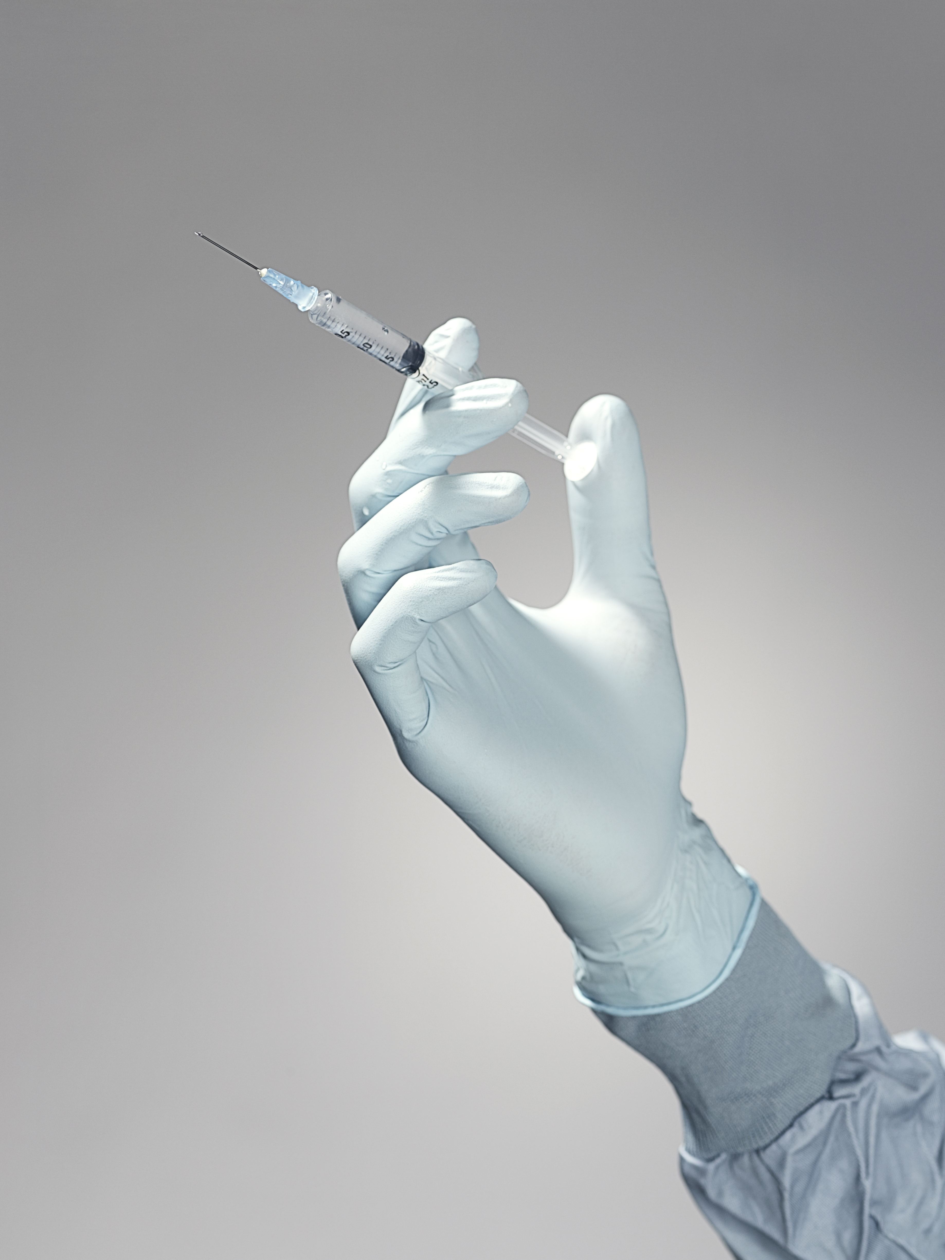 Hand holding a syringe