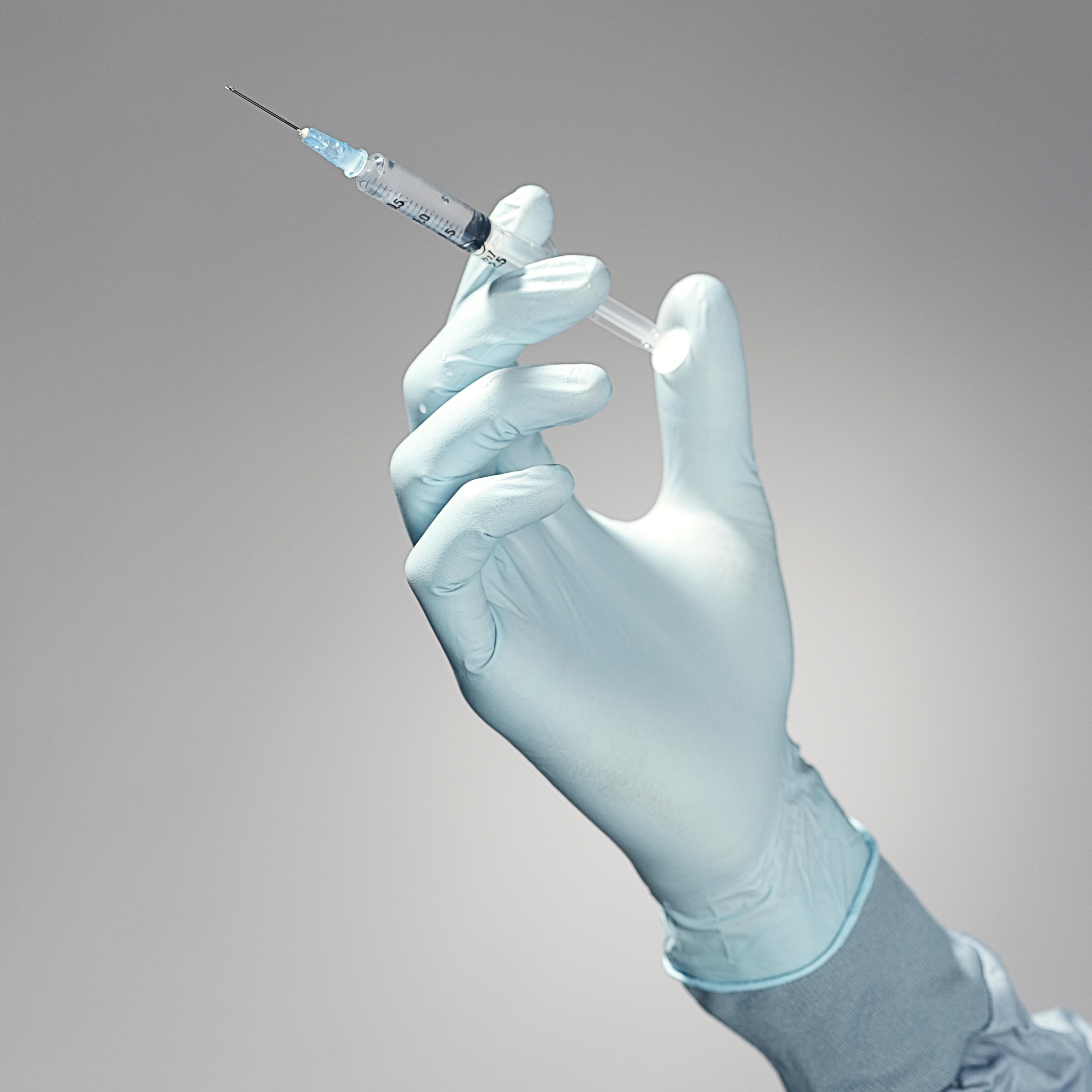 Hand holding a syringe