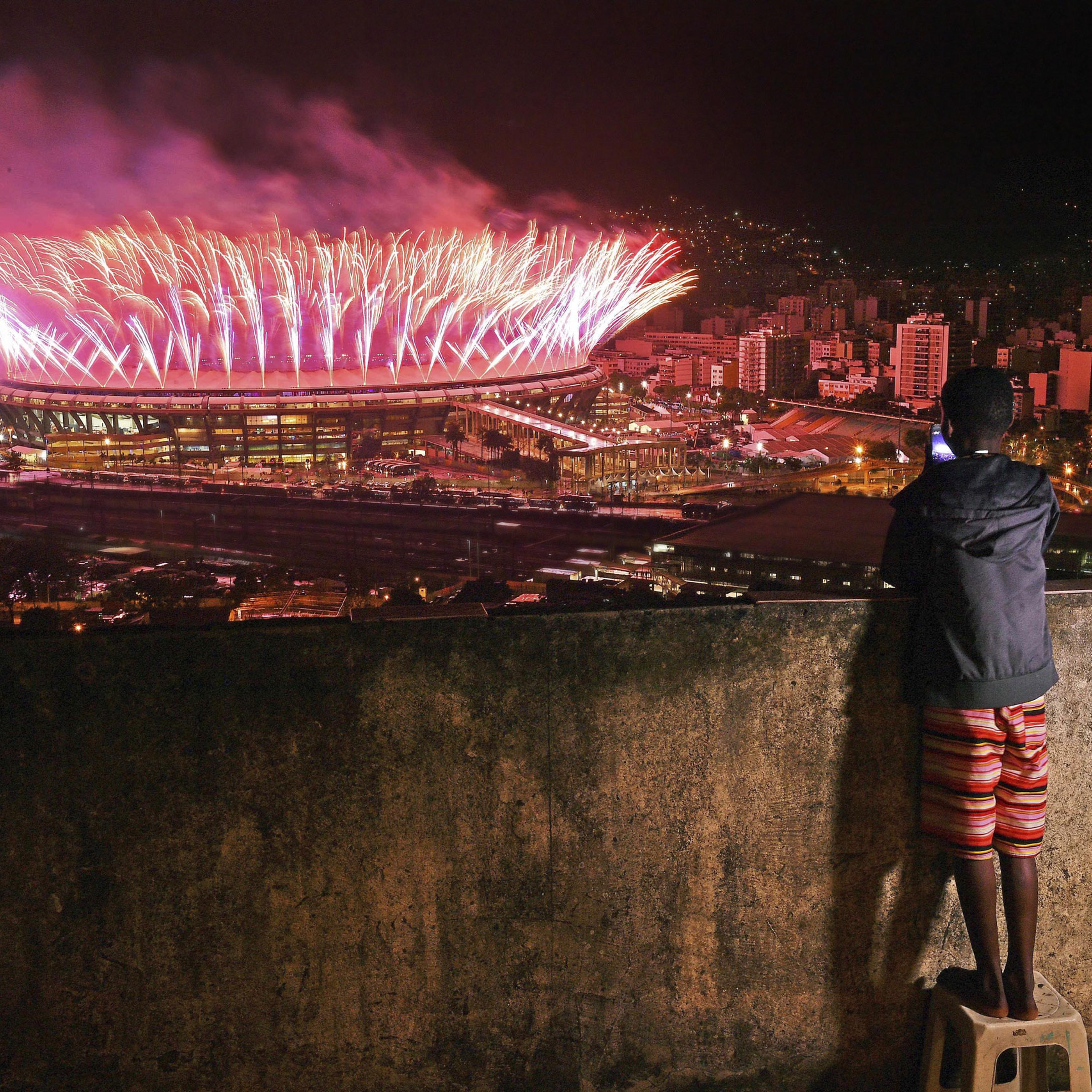 A boy watches the closing ceremony of the Rio Olympics from the Mangueira favela on Aug. 21