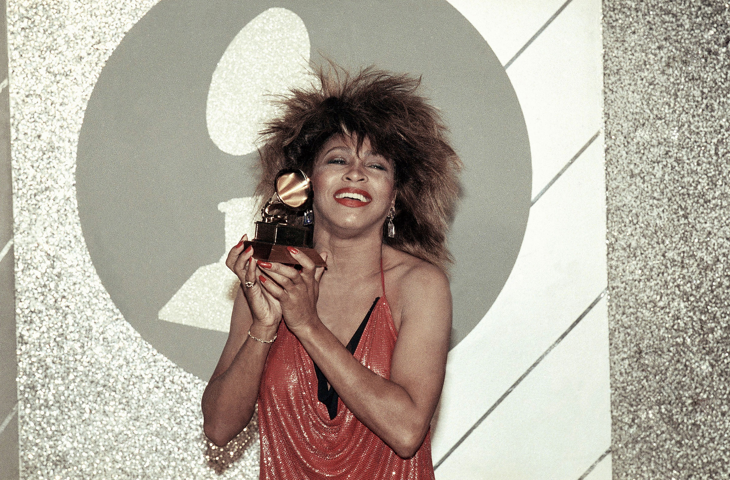 Tina Turner holds up a Grammy Award at the 27th Annual Grammy Awards in 1985.