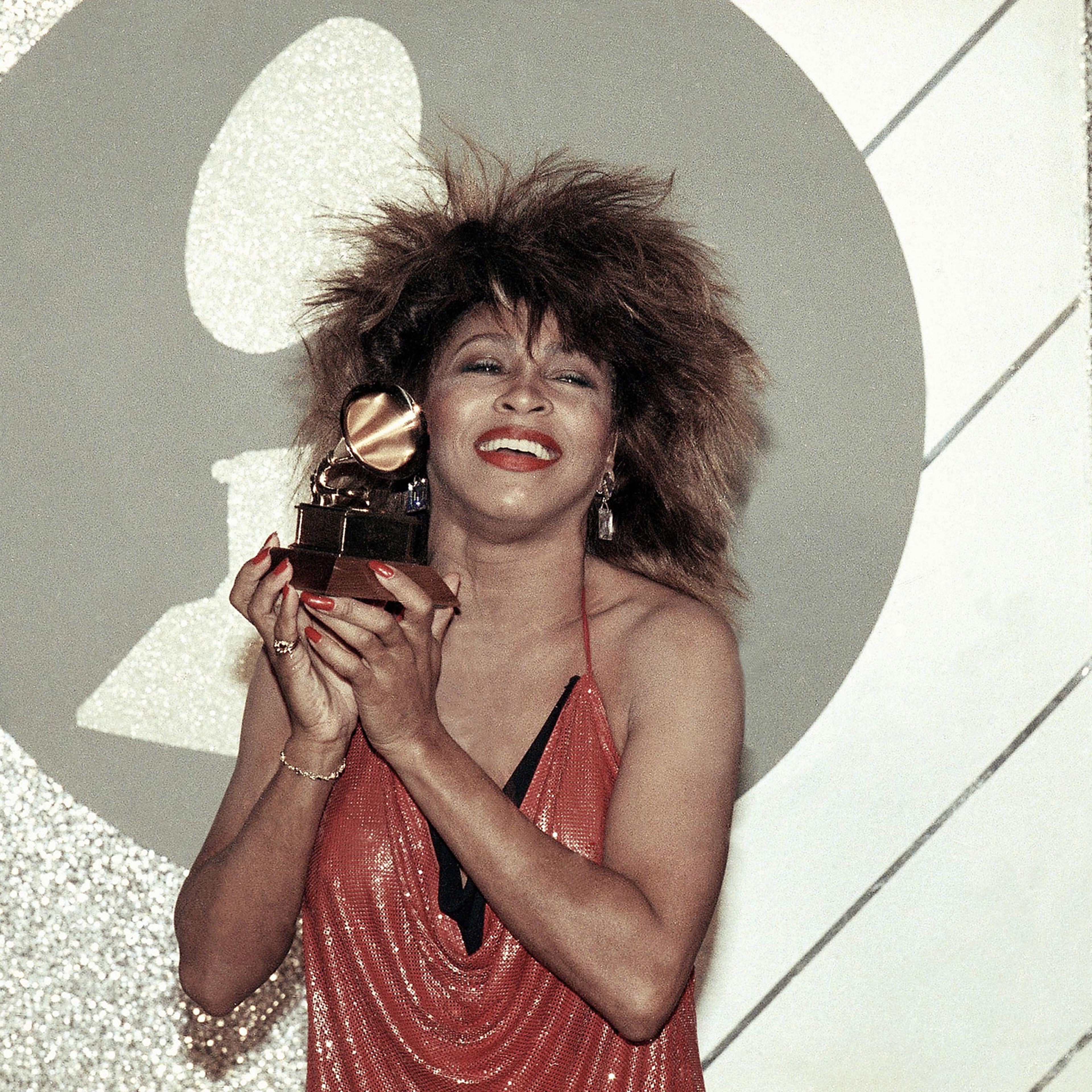 Tina Turner holds up a Grammy Award at the 27th Annual Grammy Awards in 1985.