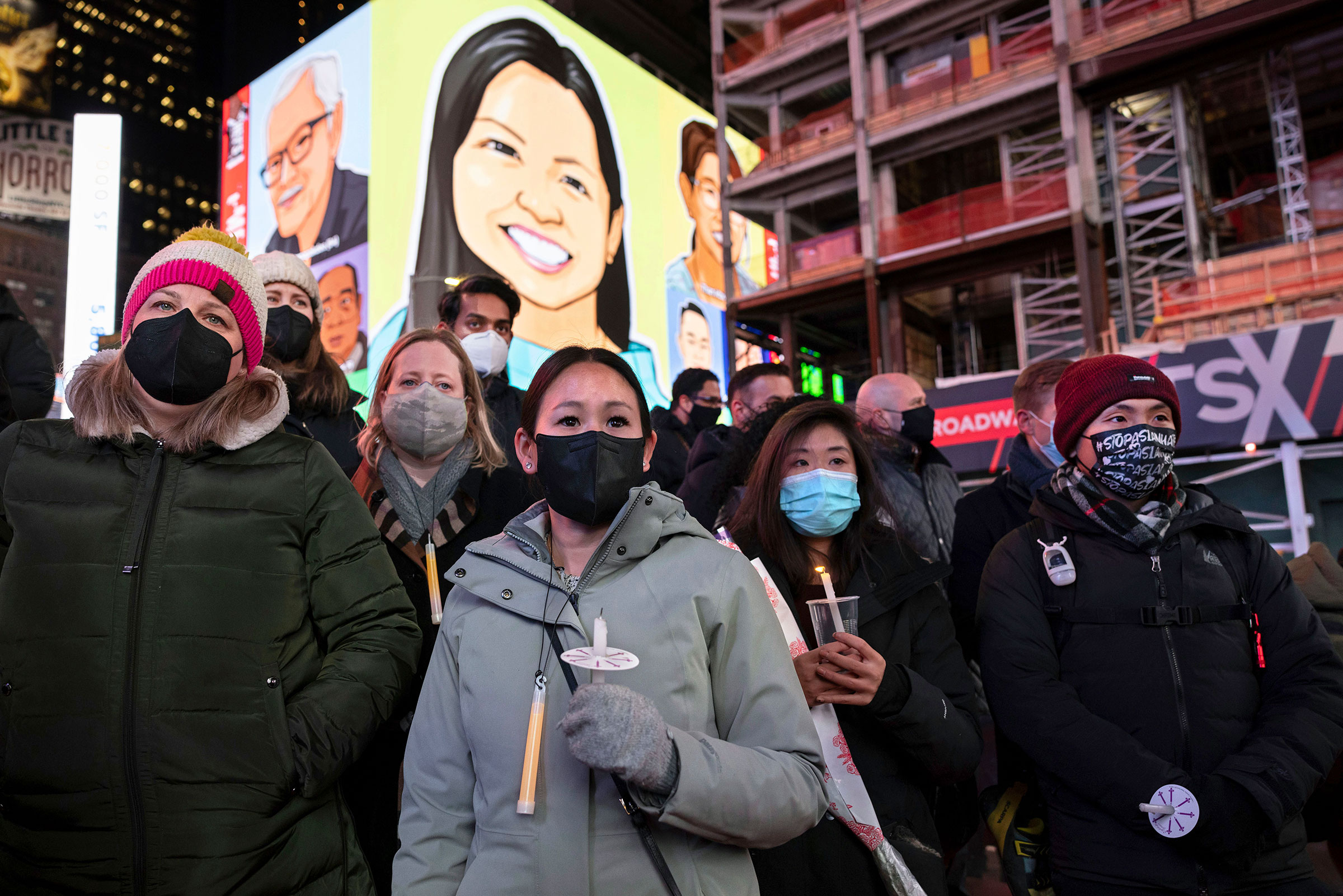 People hold candles during a vigil to honor Michelle Alyssa Go in New York's Times Square, on Jan. 18, 2022.