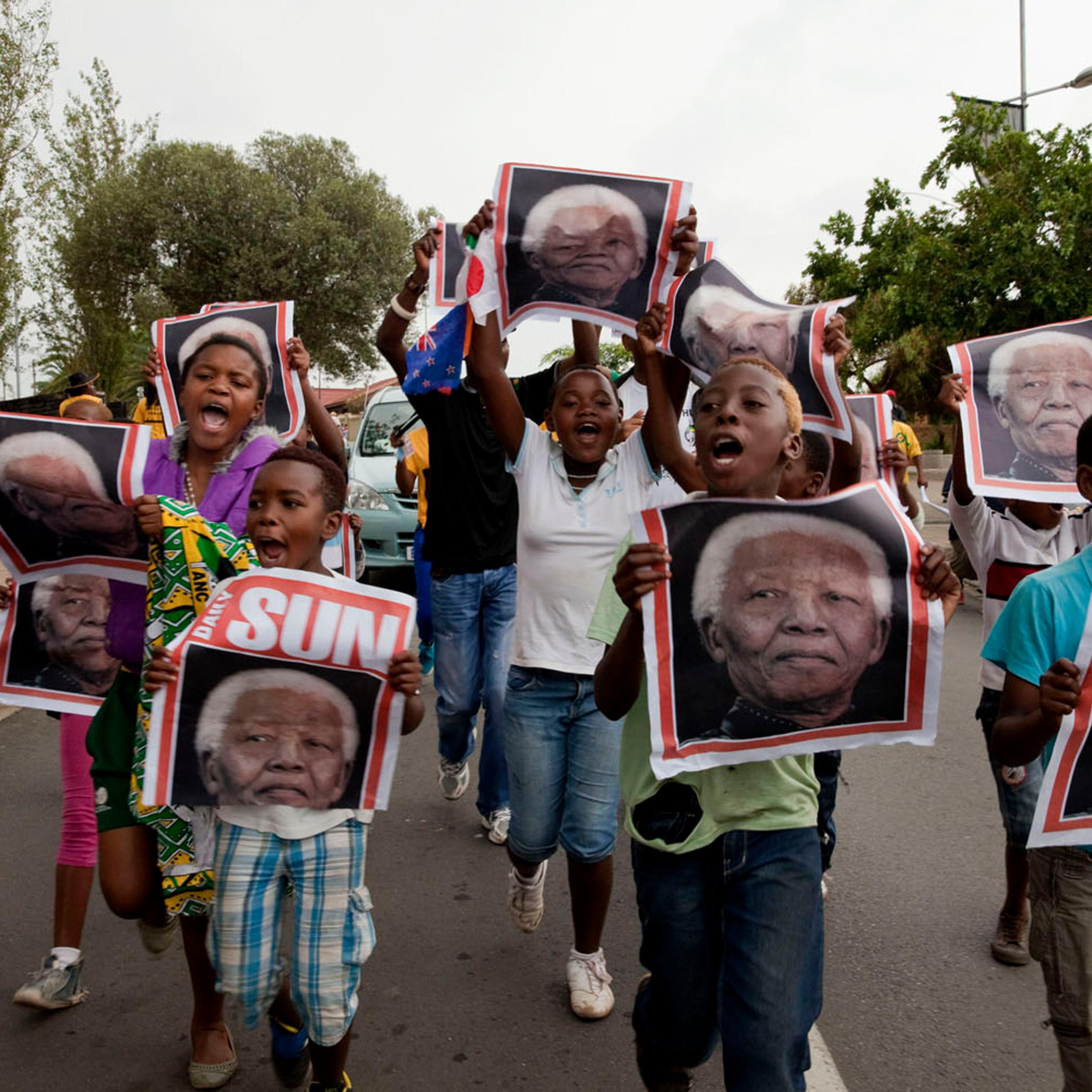 SOUTH AFRICA. Soweto. December 6, 2013. Reaction to the death of Nelson Mandela on the streets outside of his former home.