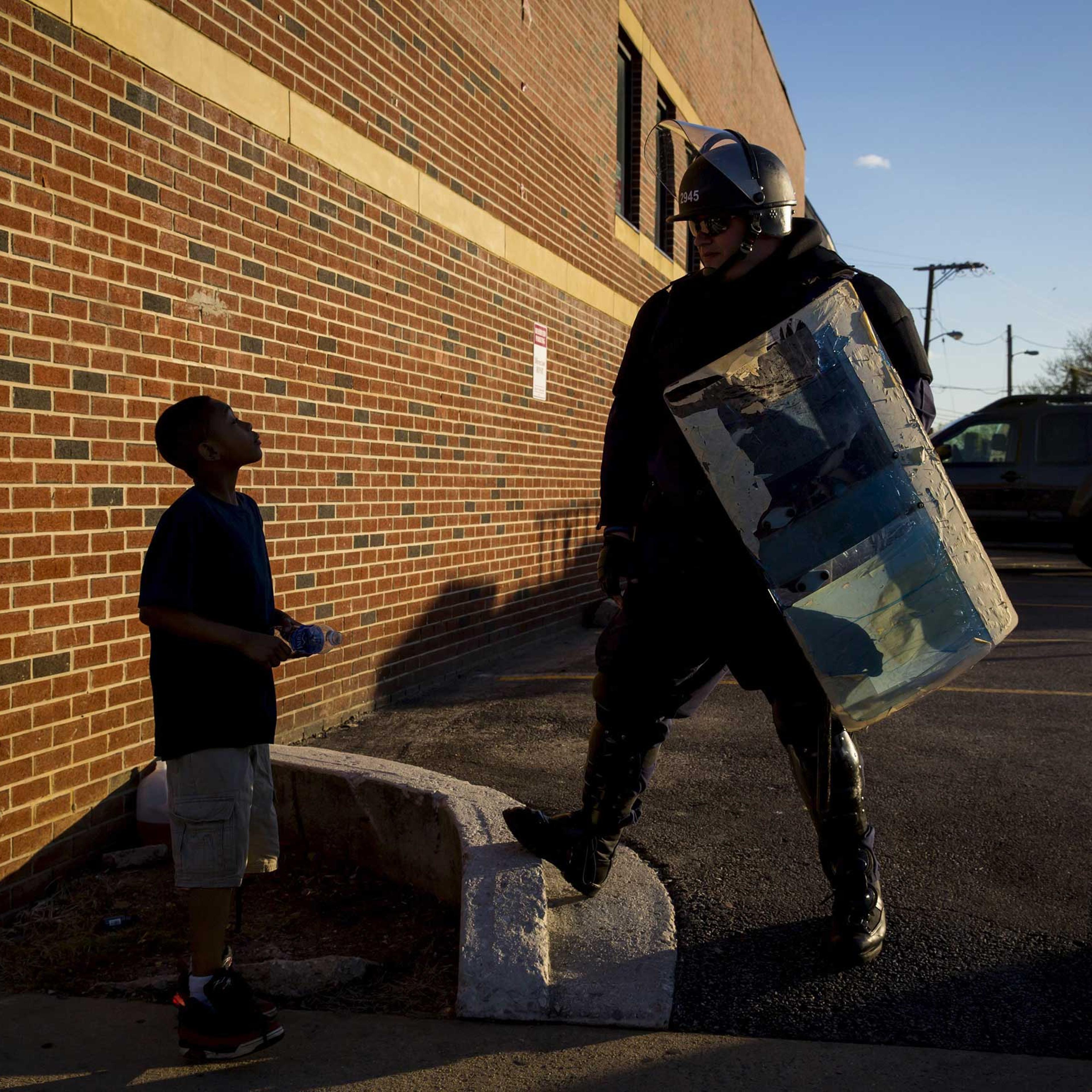 A boy talks to a police officer near North Ave and Pennsylvania Ave in Baltimore on April 28, 2015