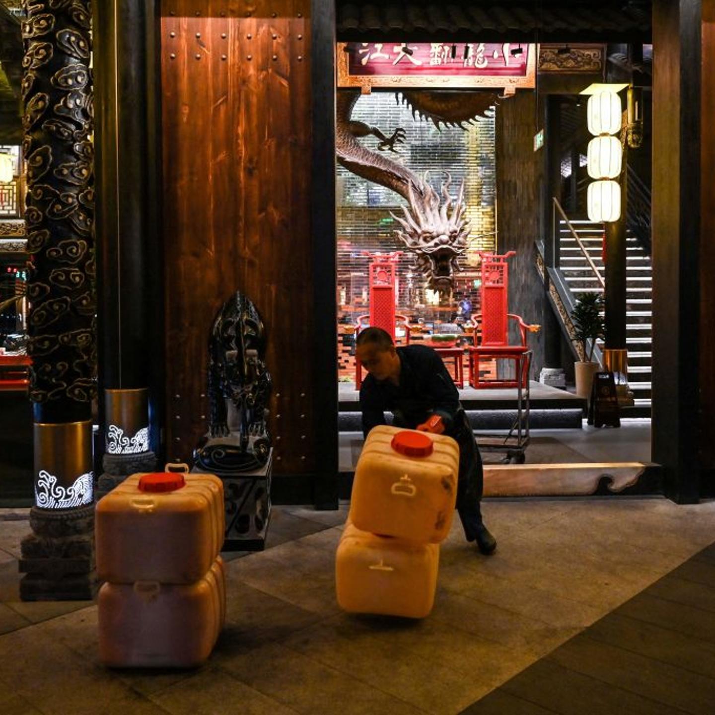 A worker carts away used oil to be recycled from a hotpot restaurant in Chengdu, China's southwest Sichuan province, on Oct. 21, 2023.