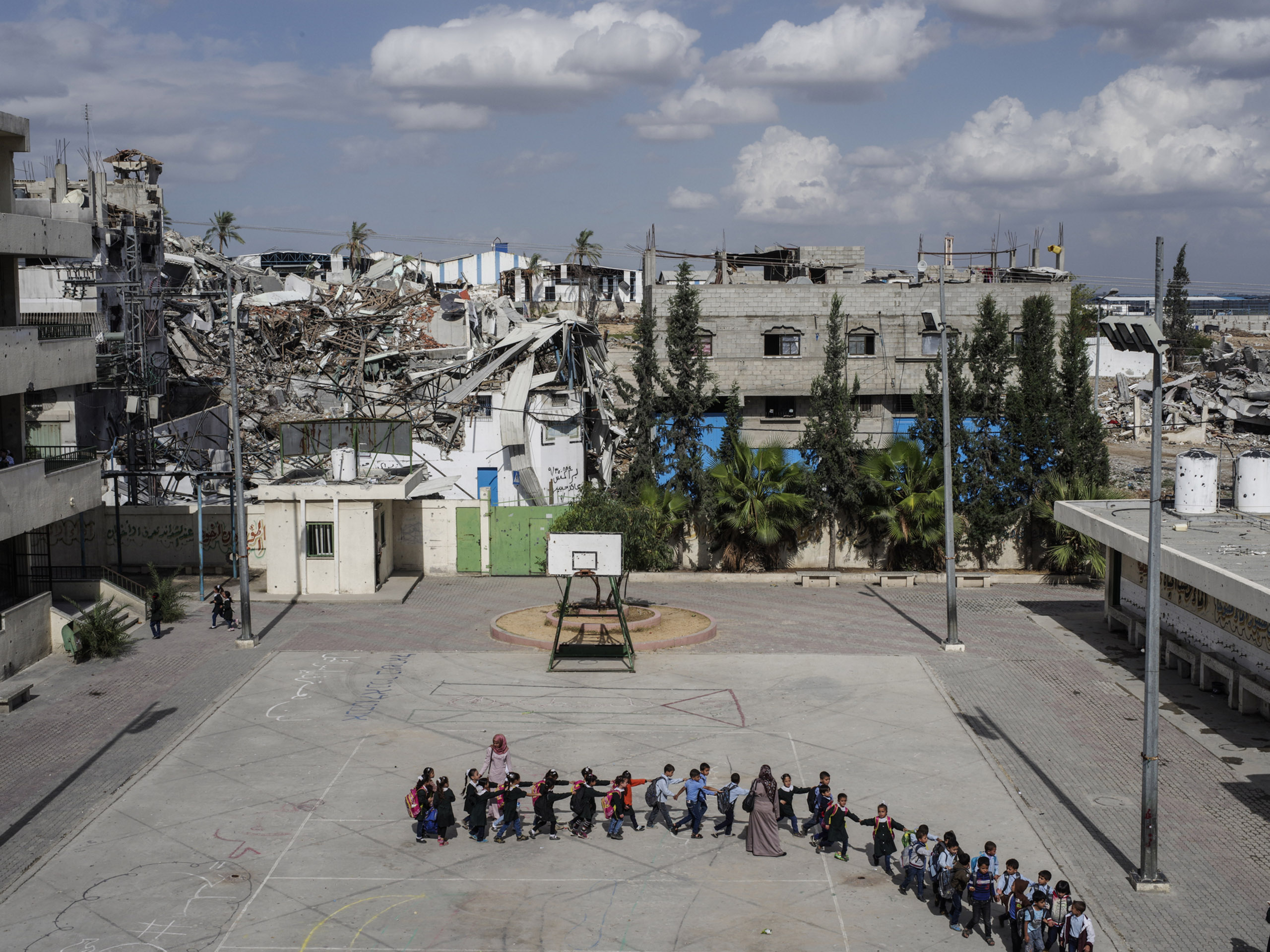 2014.  Gaza.  Palestine.  Schoolchildren head to class at the Sobhi Abu Karsh School in the Shujai'iya neighborhood. Operation Protective Edge lasted from 8 July 2014 – 26 August 2014, killing 2,189 Palestinians of which 1,486 are believed to be civilian