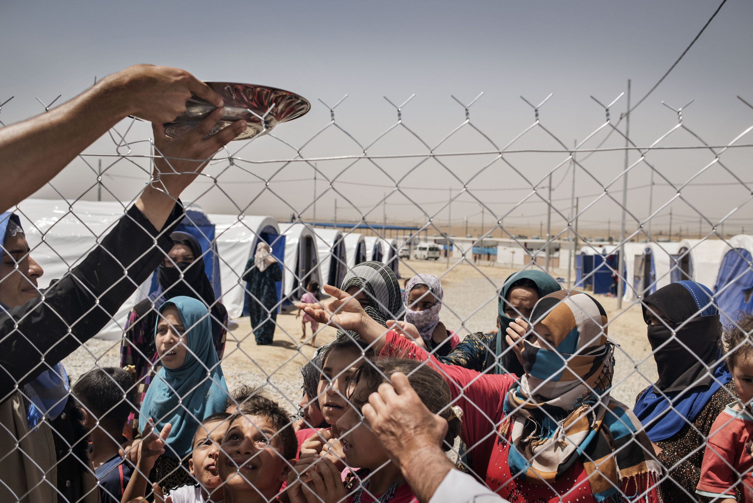 Displaced people share food in a camp near the Iraqi town of Makhmour, northern Iraq, May 2016.