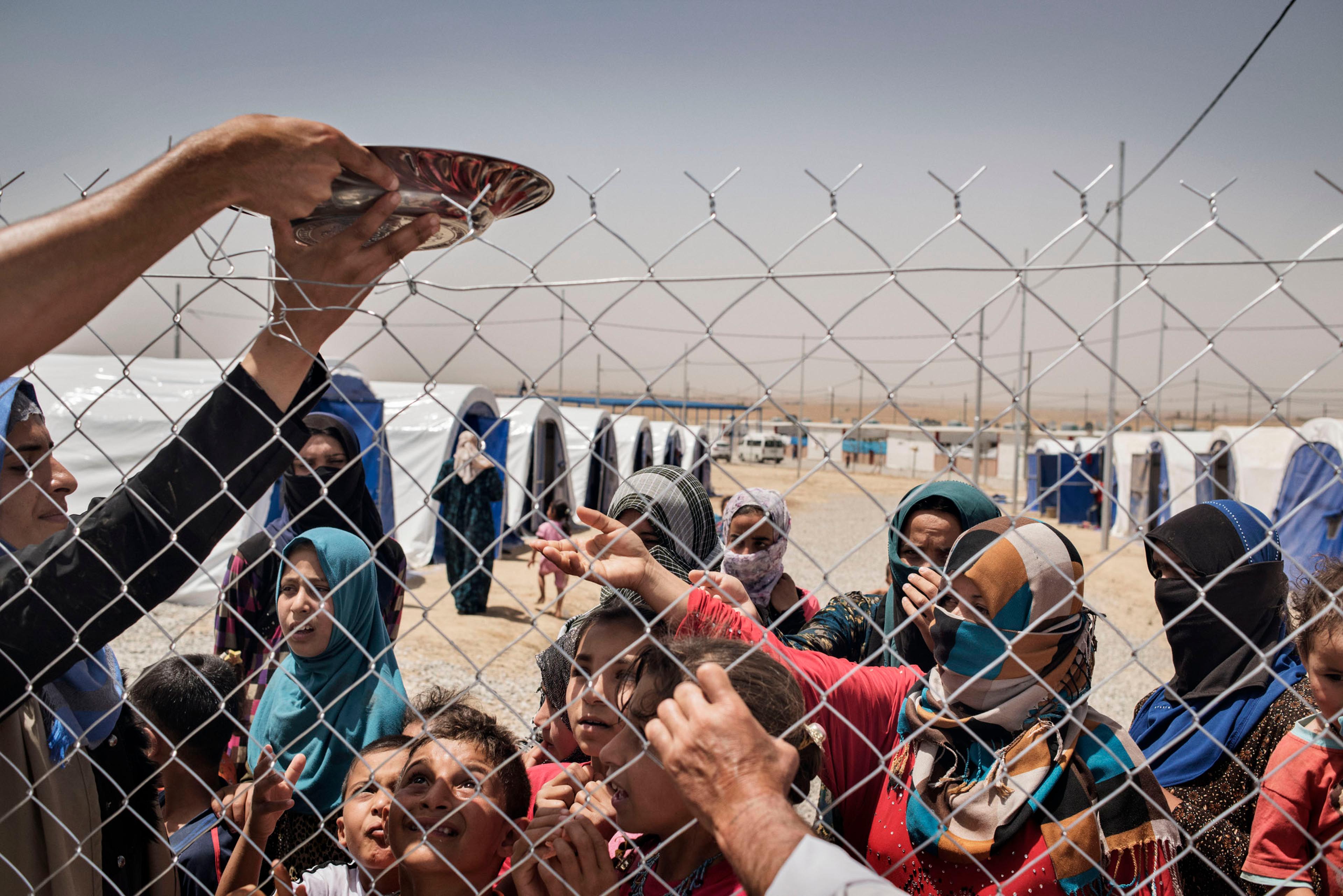 Displaced people share food in a camp near the Iraqi town of Makhmour, northern Iraq, May 2016.