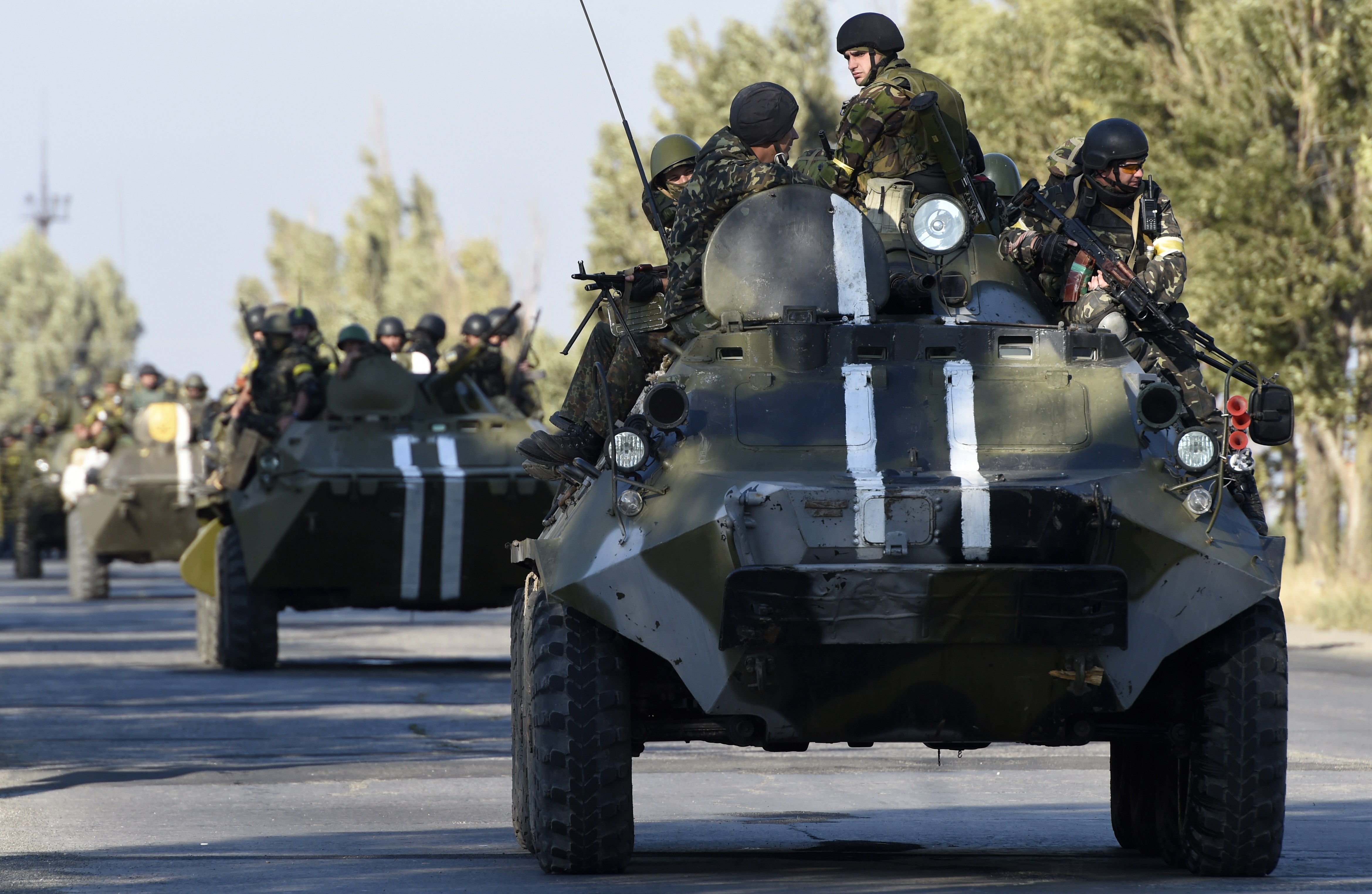 Ukrainian army soldiers go to the front line on an armoured vehicle as pro-Russian separatists fire heavy artillery, on the outskirts of the key southeastern port city of Mariupol, on Sept. 5, 2014.