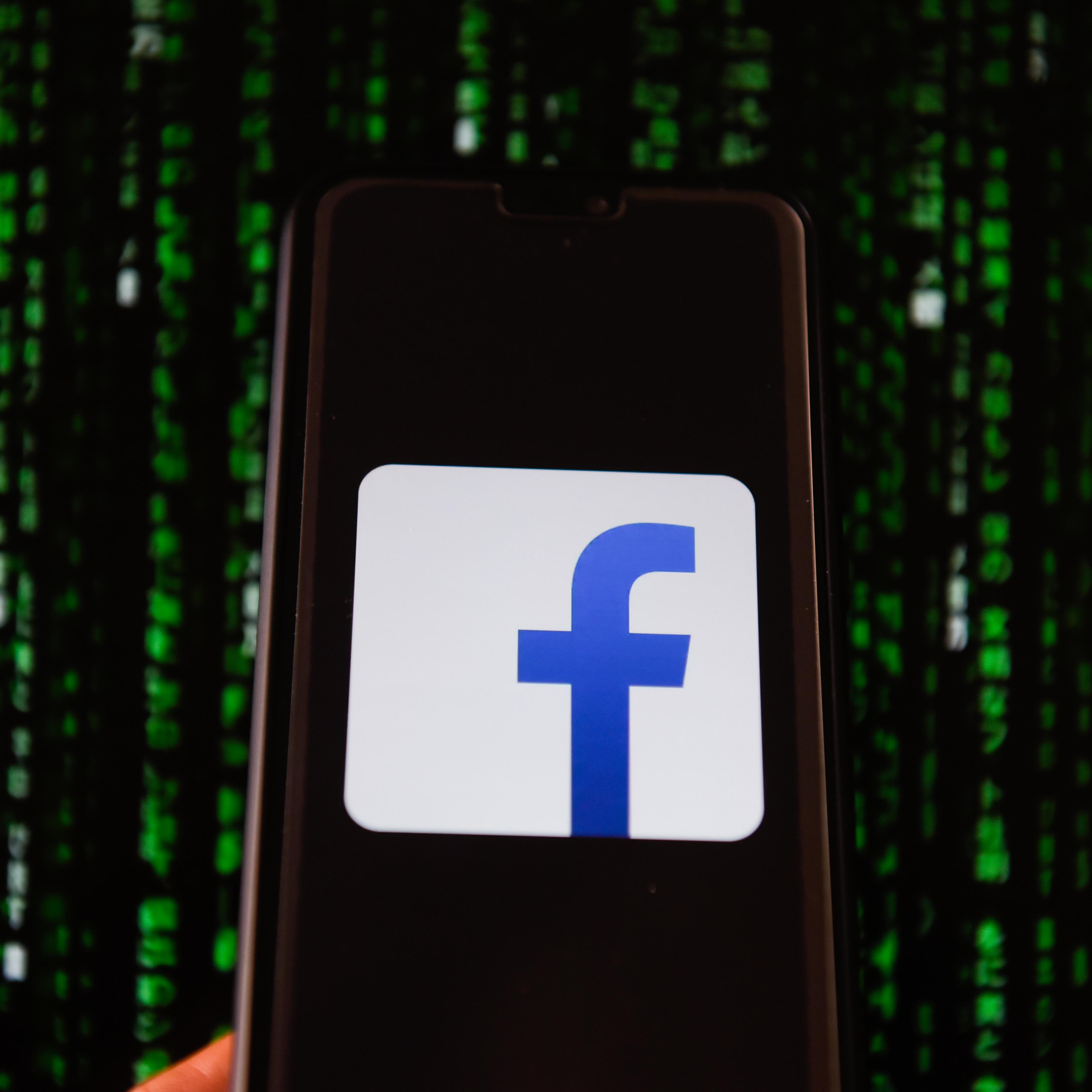 Facebook logo is seen on a mobile phone