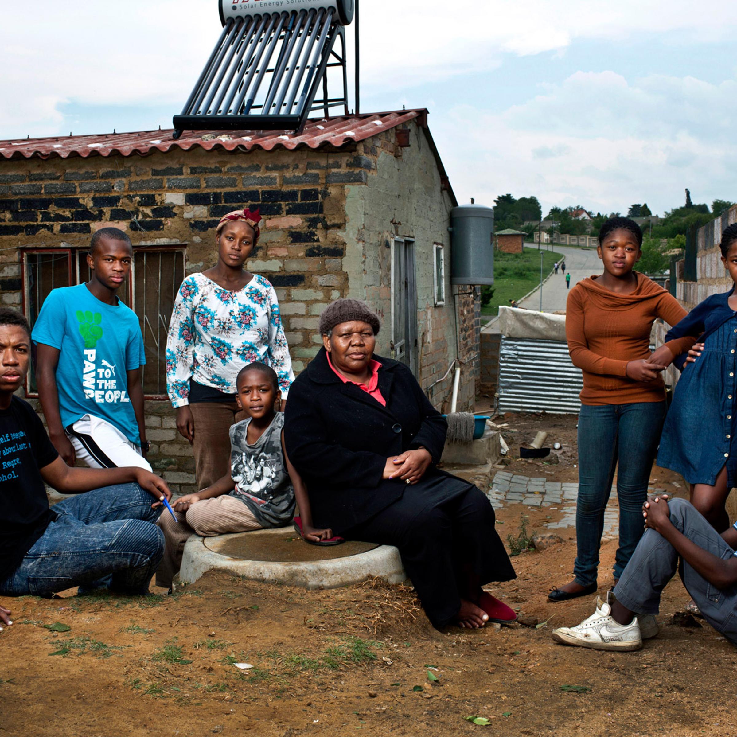 <b>Maria Mokoena, 62, with her seven orphan grandchildren. Alexandra township, Johannesburg, South Africa; October 2012.</b>
<br><br>
In 2003, Mokoena began taking care of grandchildren Ernest, now 21, and Lebusa, now 17, after her eldest daughter died of HIV/AIDS. This May, her second daughter also died of the disease, leaving her to raise five more grandchildren: Teddy, 8, Happy, 13, and Sharon, 15, Mbongeni, 17, and Lineo, 23. The grandchildren don't know how their mothers died. "They are too young to understand," Mokoena says. "This disease eats you from the inside until it is too late. I hope for a better life for my grandchildren. I want them to become accountants and lawyers.”