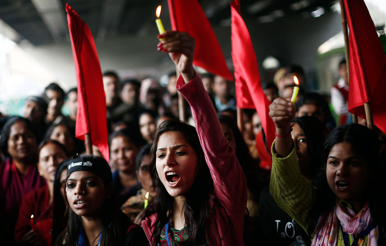 Protesters carry candles as they shout slogans during a protest to mark the first anniversary of the Delhi gang rape, in New Delhi