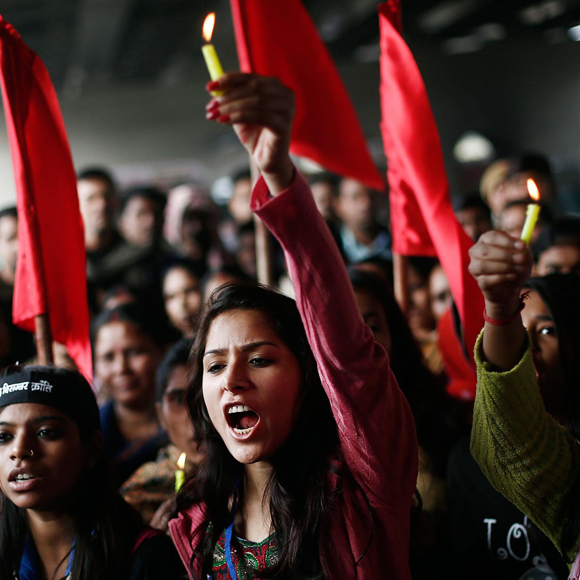 Protesters carry candles as they shout slogans during a protest to mark the first anniversary of the Delhi gang rape, in New Delhi