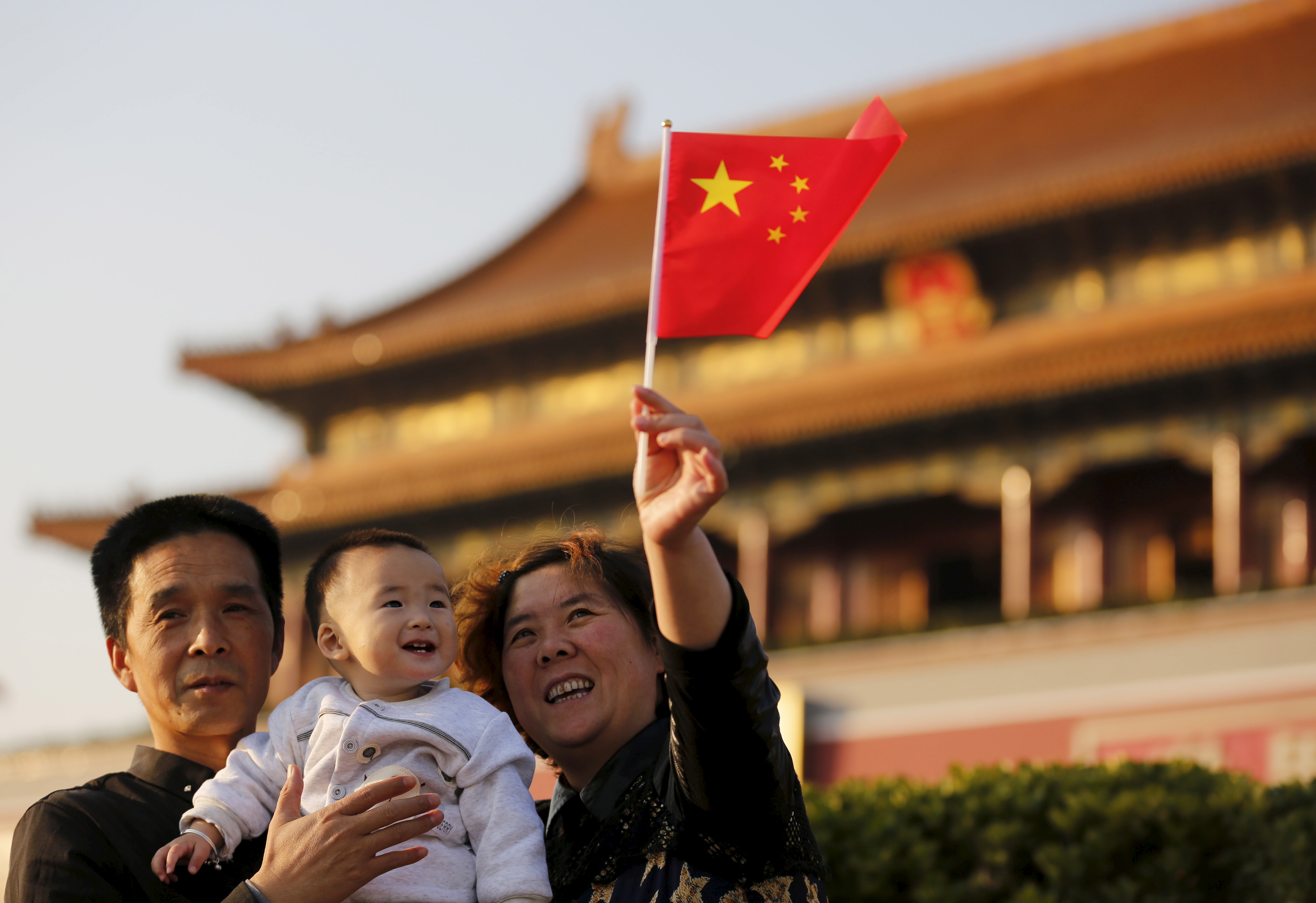 Guan Junze and his grandparents take their souvenior picture in front of the Tiananmen Gate in Beijing