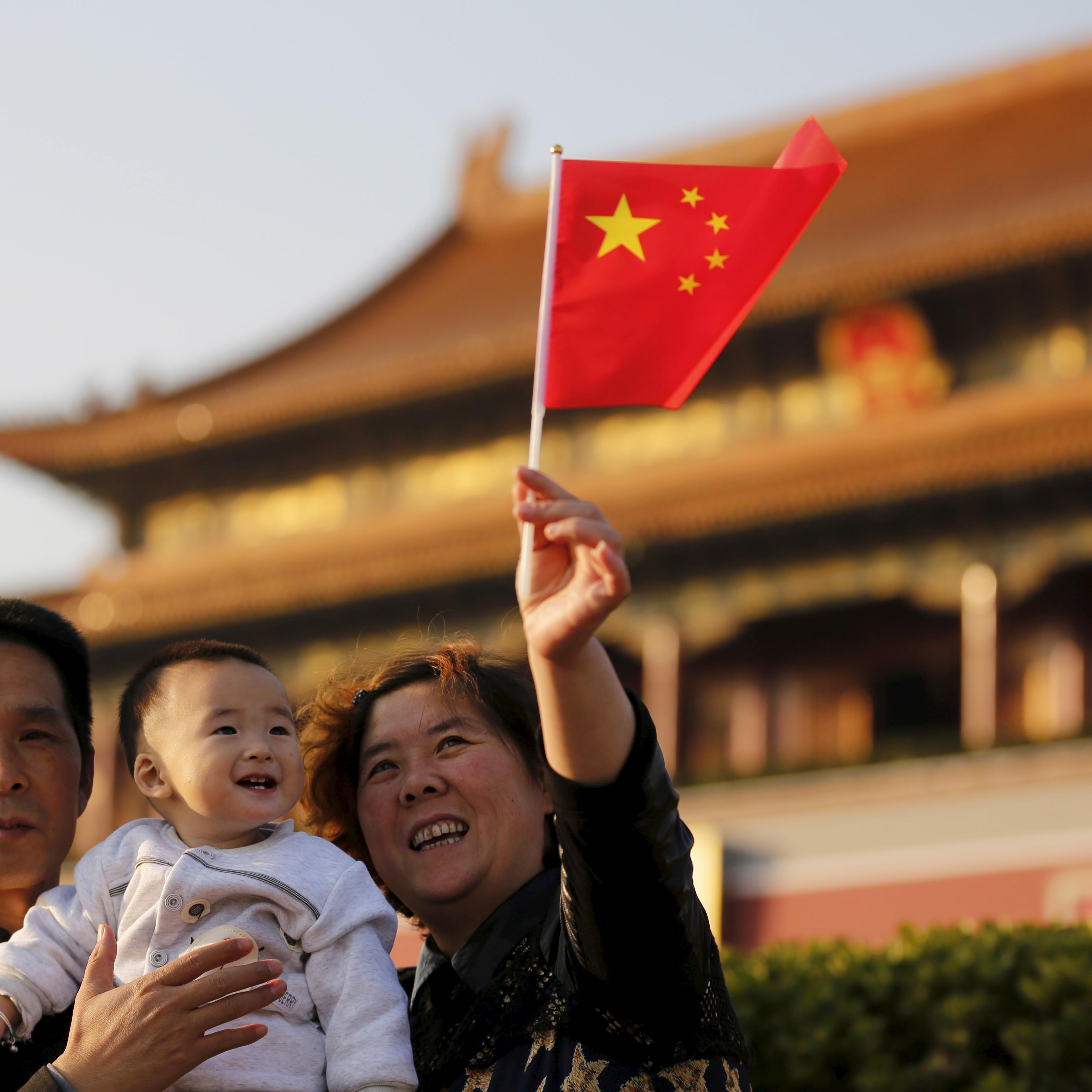 Guan Junze and his grandparents take their souvenior picture in front of the Tiananmen Gate in Beijing