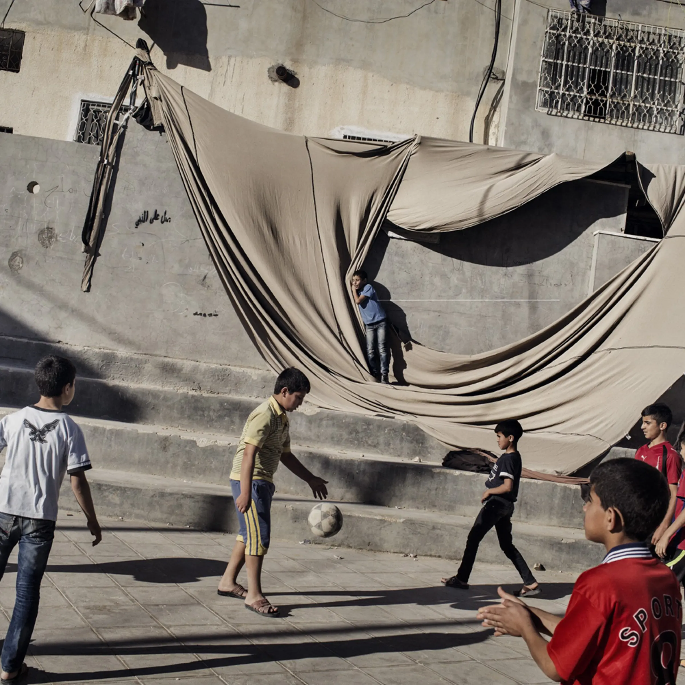 Children play soccer in a plaza in Al Fawwar, a Palestinian refugee camp in the West Bank, June 15, 2014.