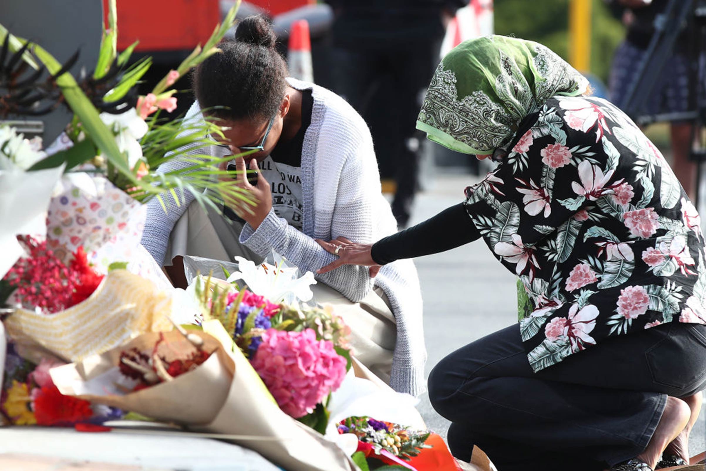 Locals lay flowers in tribute to those killed and injured near the Al Noor Mosque on March 16, 2019, in Christchurch, New Zealand.