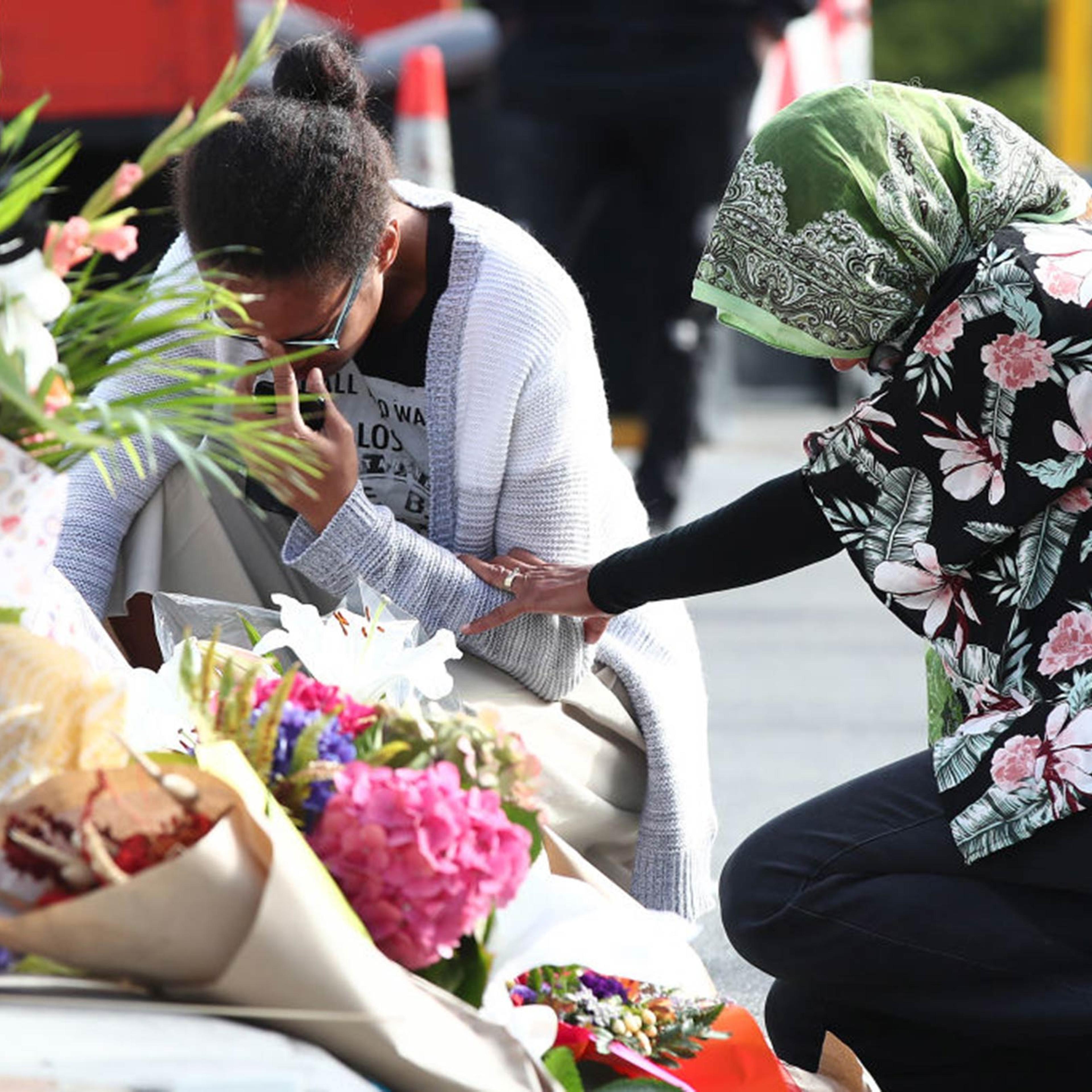 Locals lay flowers in tribute to those killed and injured near the Al Noor Mosque on March 16, 2019, in Christchurch, New Zealand.