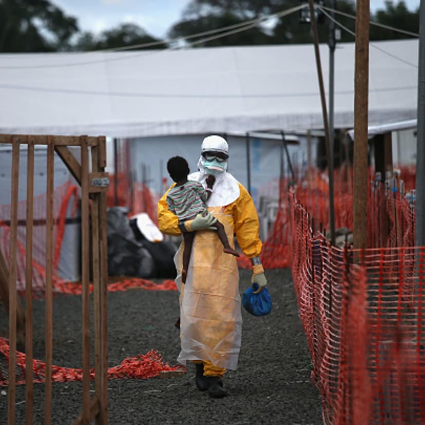 A Doctors Without Borders (MSF), health worker in protective clothing carries a child suspected of having Ebola in the MSF treatment center on October 5, 2014 in Paynesville, Liberia.